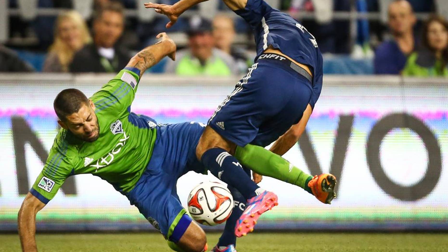 Seattle Sounders player Clint Dempsey tangles with a Vancouver Whitecaps player in the second half on Friday, October 10, 2014. The Whitecaps won the Cascadia Cup after beating the Sounders 1-0. (AP Photo/seattlepi.com, Joshua Trujillo)