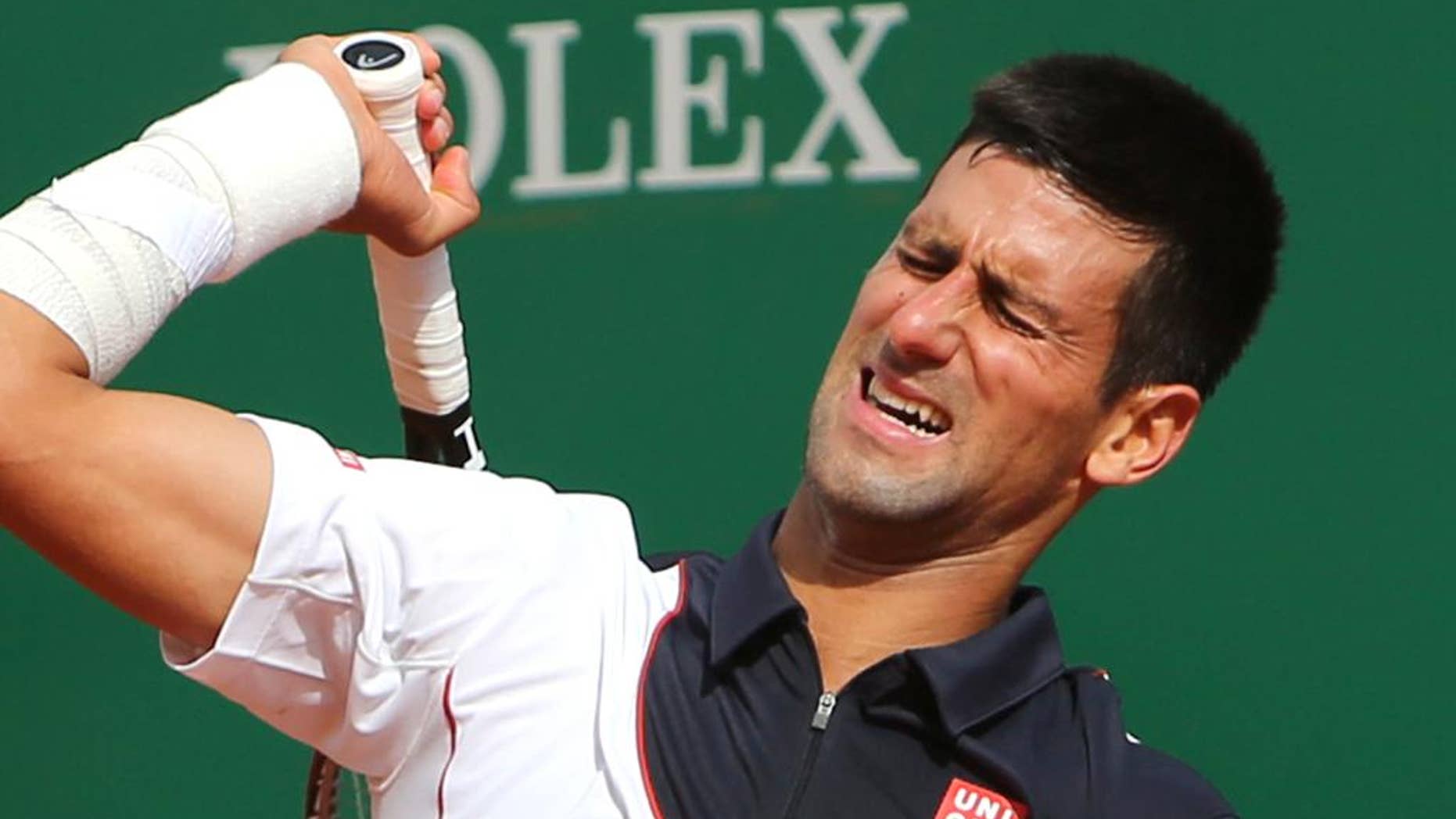 Novak Djokovic reacciona después de perder un punto frente a Roger Federer en semifinales del Masters de Montecarlo el 19 de abril del 2014. (AP Foto/Claude Paris)