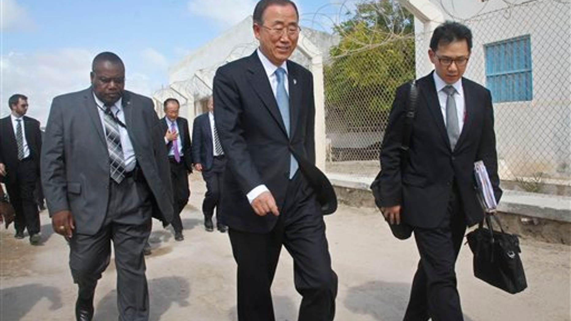 U.N. Secretary General Ban Ki-moon, center, walks inside the heavily-protected airport complex during a visit to Mogadishu, Somalia, Wednesday, Oct. 29, 2014. (AP Photo/Farah Abdi Warsameh)