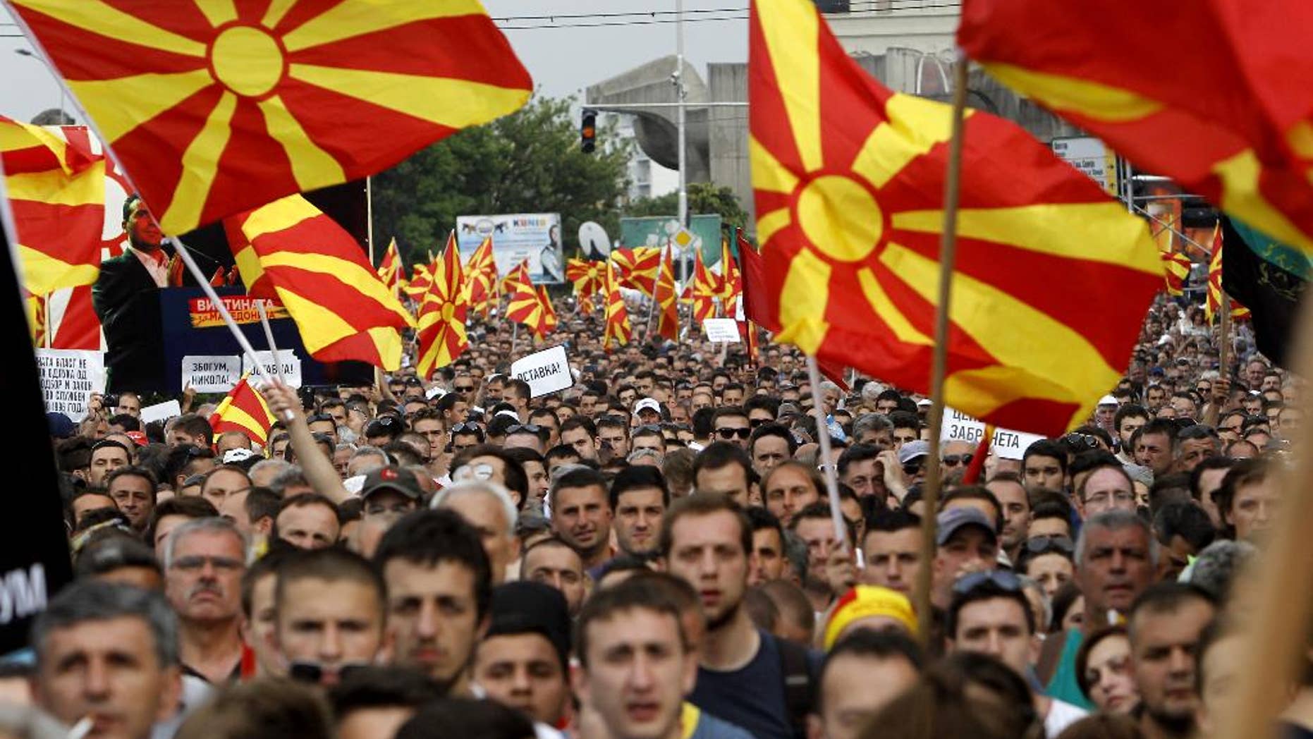 People wave national flags during a protest in front of the Government building in Skopje, Macedonia, on Sunday, May 17, 2015. Macedonian opposition started massive demonstrations Sunday in Skopje protesting against the conservative government of the Prime Minister Nikola Gruevski, demanding its resignation. (AP Photo/Boris Grdanoski)