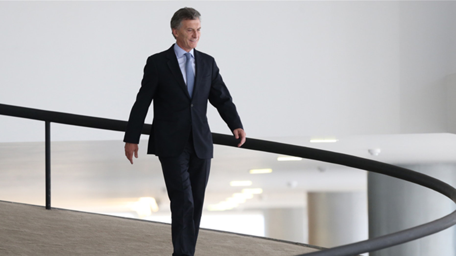 In this Friday, Dec. 4, 2015 photo, Argentina's President-elect Mauricio Macri walks down an inner ramp of the Planalto Presidential Palace, after meeting with Brazils President Dilma Rousseff, in Brasilia, Brazil. Macri, who won a presidential runoff election over the ruling party candidate in late November, is making his first official state visit as the next leader of Argentina. (AP Photo/Eraldo Peres)