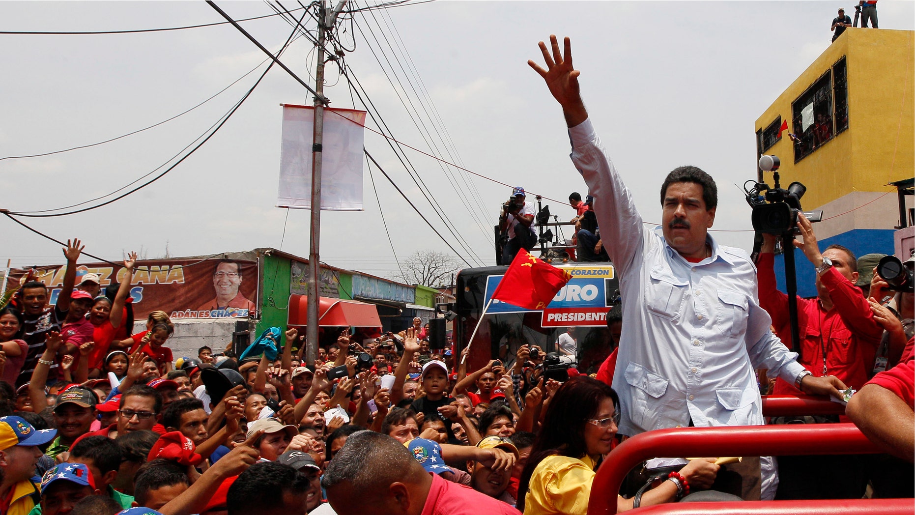 Venezuela's interim President Nicolas Maduro waves to supporters from the top of a vehicle as he campaigns in a caravan from Sabaneta to Barinas, in Sabaneta, Venezuela, Tuesday, April 2, 2013. A former union leader and bus driver, Maduro is competing against opposition leader Henrique Capriles in the April 14 presidential election. Invoking the late President Hugo Chavez during a televised speech on Tuesday, Maduro declared: "This victory will belong to our commander!" (AP Photo/Ariana Cubillos)