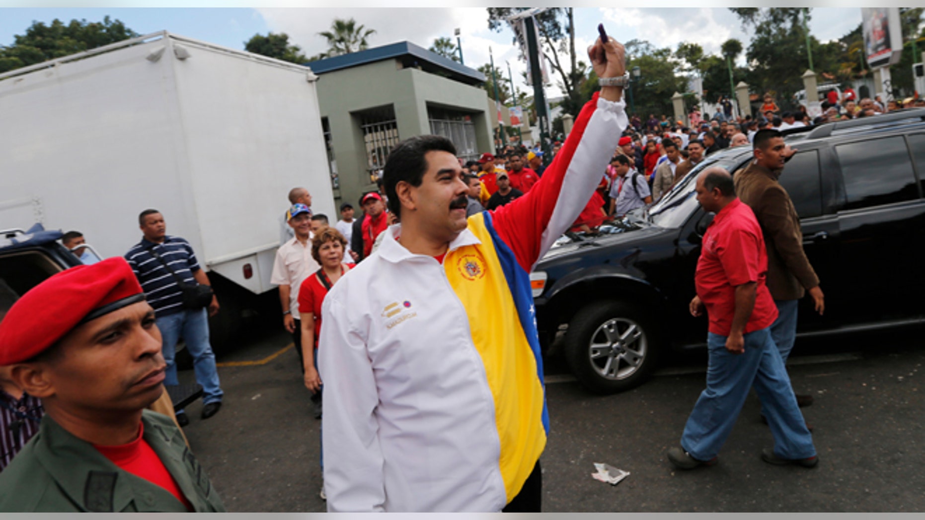 Venezuela's President Nicolas Maduro shows his inked finger after casting his vote during municipal elections in Caracas, Venezuela, Sunday, Dec. 8, 2013. Venezuelans head to the polls to elect mayors and city councilors at a moment when the country's economic troubles have deepened, with inflation touching a two-decade high of 54 percent, and shortages of everything from toilet paper to milk spreading while the black market value of the currency plunges. (AP Photo/Fernando Llano)