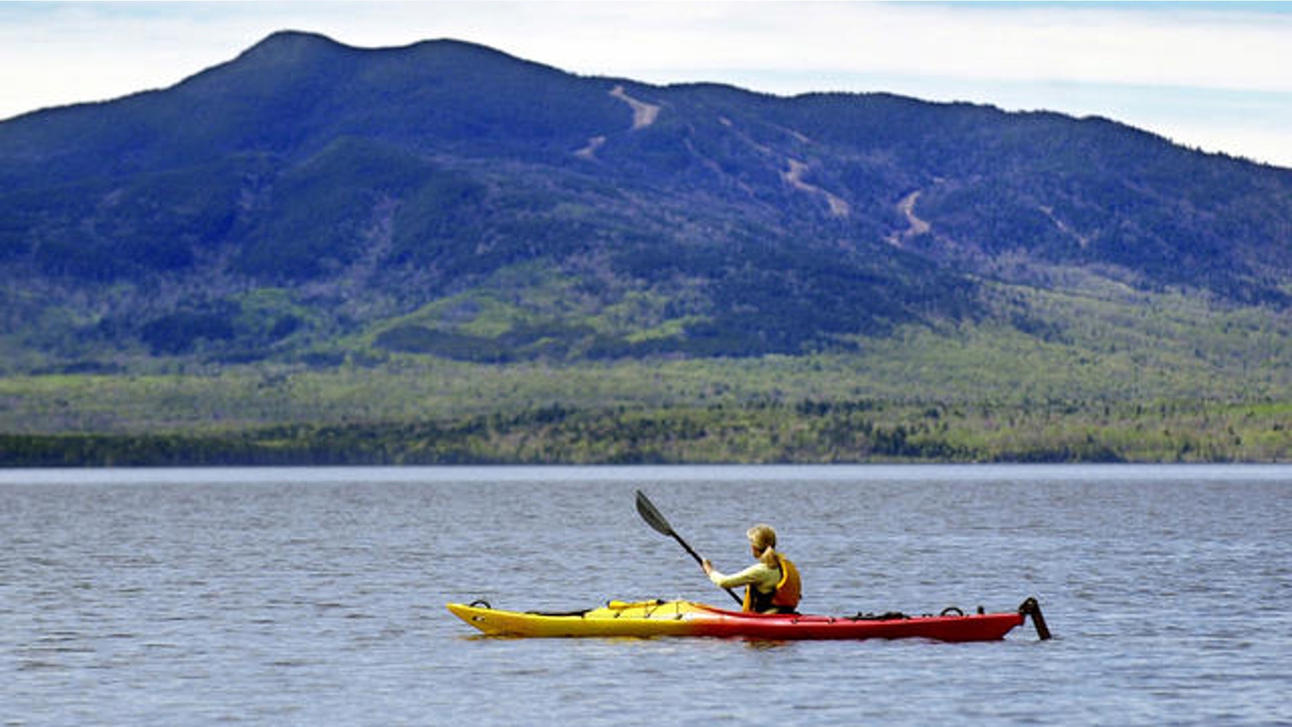 Kayaker paddles on Moosehead Lake at Lily Bay State Park, Beaver Cove, Maine.