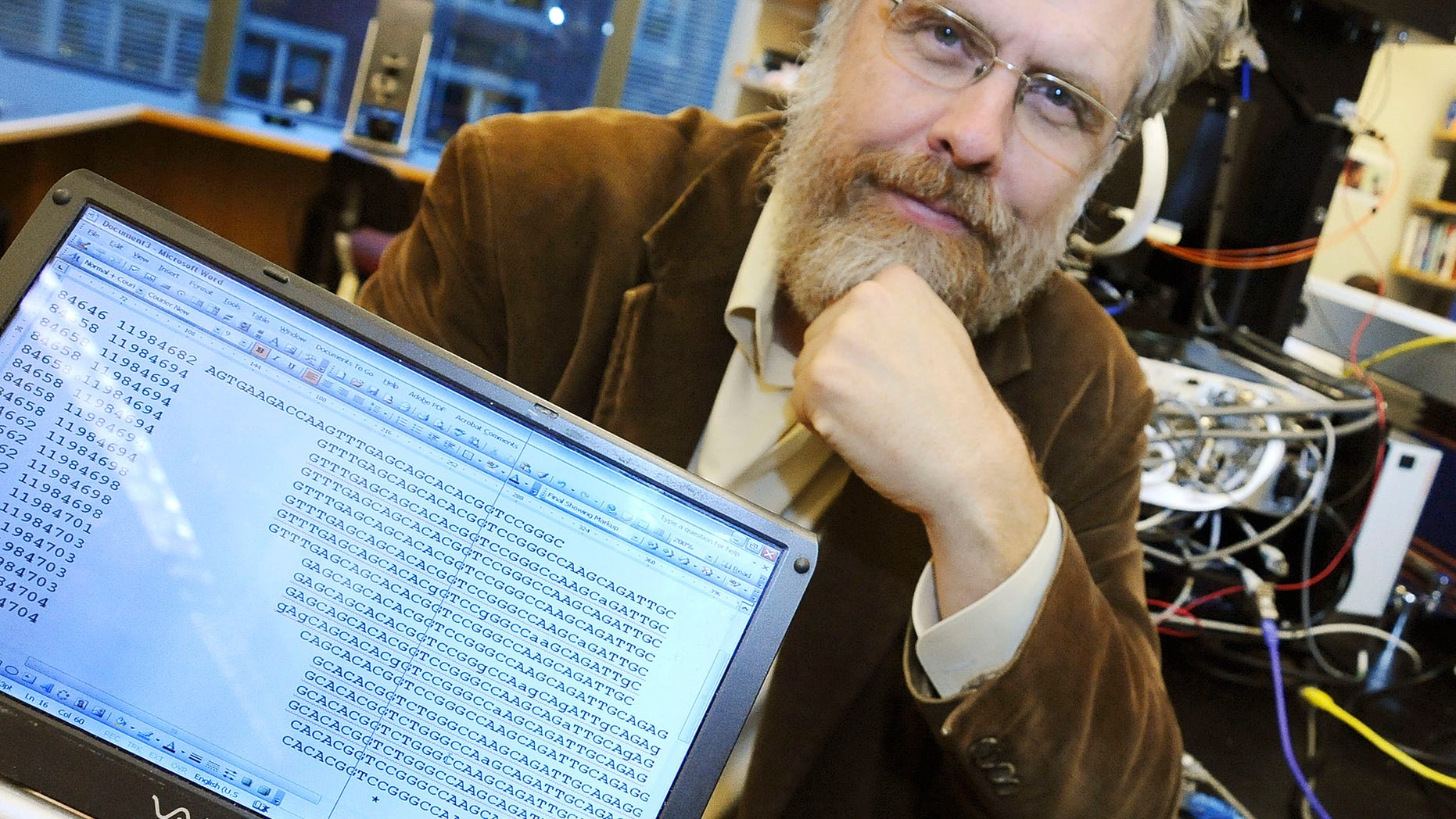 In this Oct. 20, 2008 file photo, Harvard Medical School genetics professor George Church poses for a photo with DNA sequence data for Dr. John Halamka, chief information officer, following a news conference in Boston.