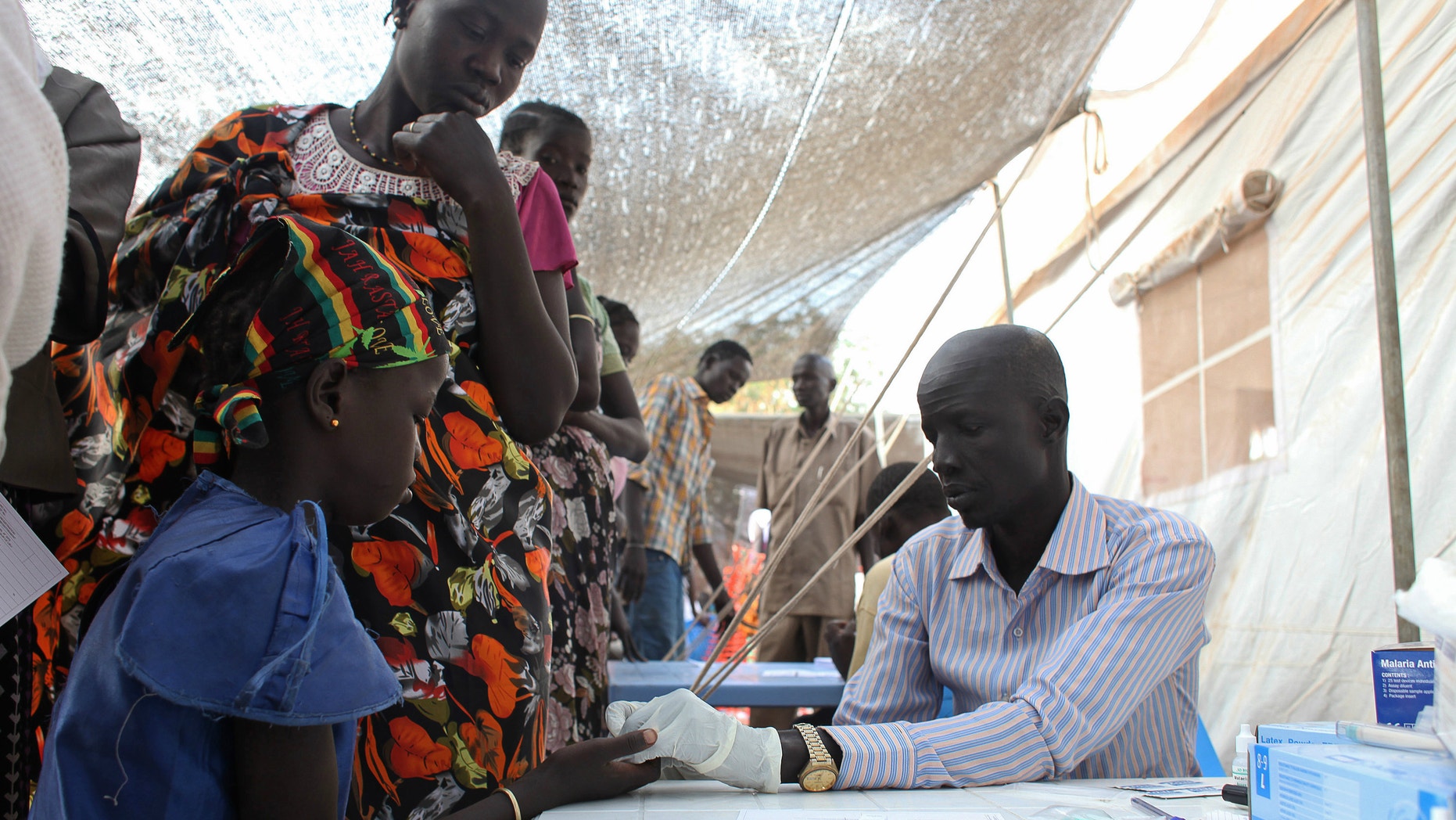 A displaced girl is tested for malaria at an MSF clinic in Tomping camp
