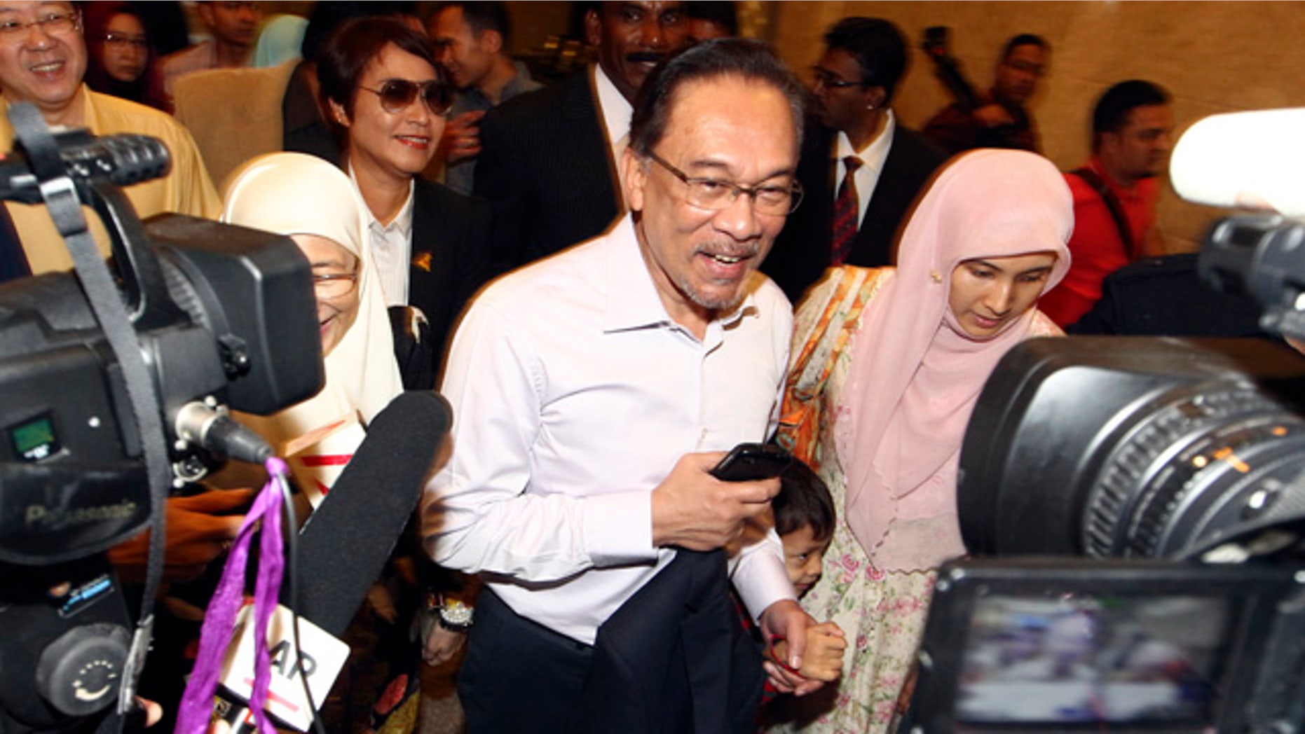Feb. 10, 2015: Malaysian opposition leader Anwar Ibrahim, center, arrives at court house in Putrajaya. Malaysia's top court on Tuesday upheld Anwar's sodomy conviction in a case seen at home and aboard as politically motivated to eliminate any threats to the government. (AP Photo)