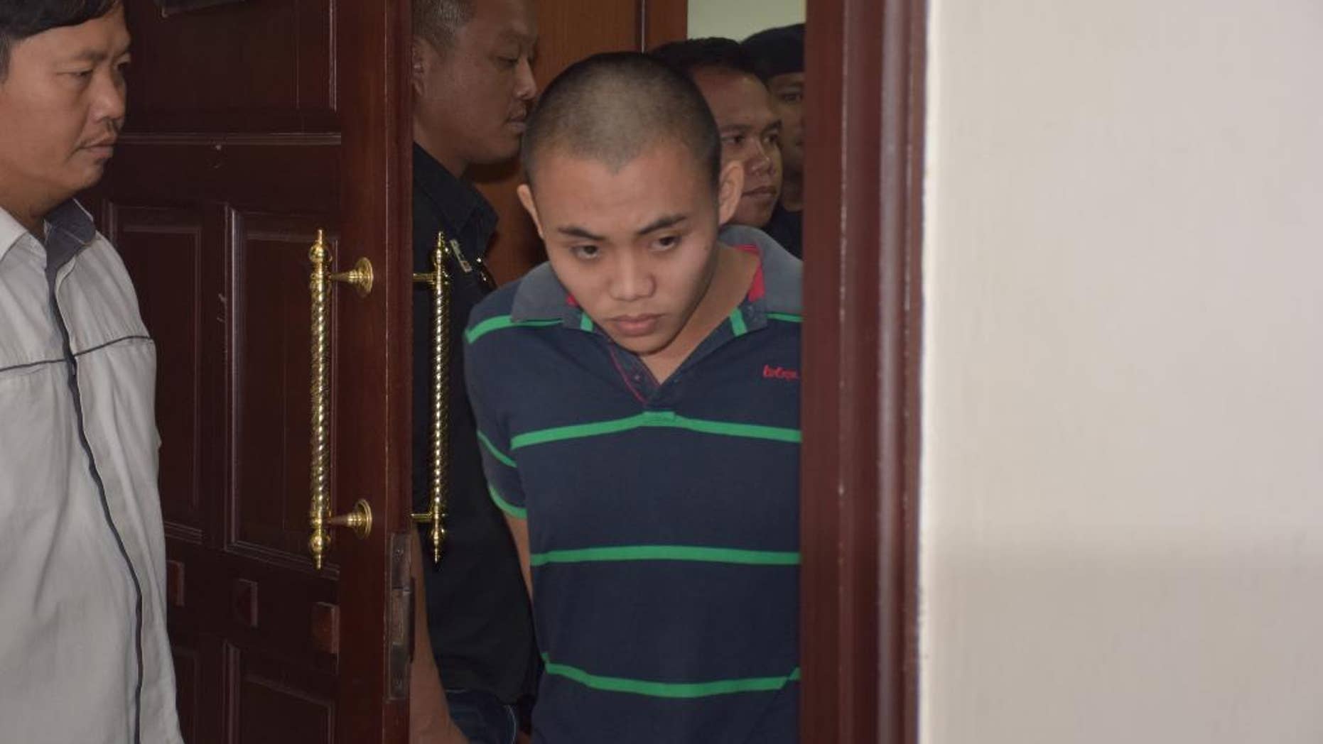 Zulkipli Abdullah, 23, center, walks out from a courtroom in Kuching, Malaysia, on Tuesday, March 31, 2015. On Tuesday, Prosecutor Muhamad Iskandar Ahmad said the high court found Zulkipli guilty of stabbing to death Aidan Brunger and Neil Gareth Dalton, two British medical students, on Borneo island last August. (AP Photo)