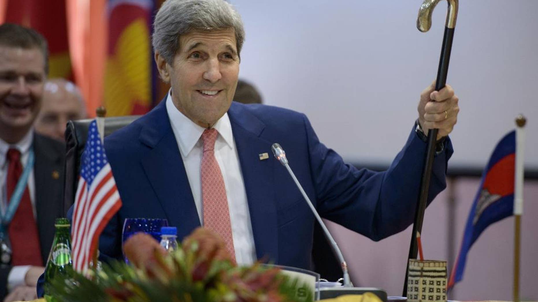 U.S. Secretary of State John Kerry holds up Joseph Kennedy's cane, which has been used by John F. Kennedy and Ted Kennedy, while talking about his broken leg during the 8th Lower Mekong Initiative Ministerial Meeting at the Putra World Trade Center in Kuala Lumpur, Malaysia Wednesday, Aug. 5, 2015. (Brendan Smialowski/Pool Photo via AP)