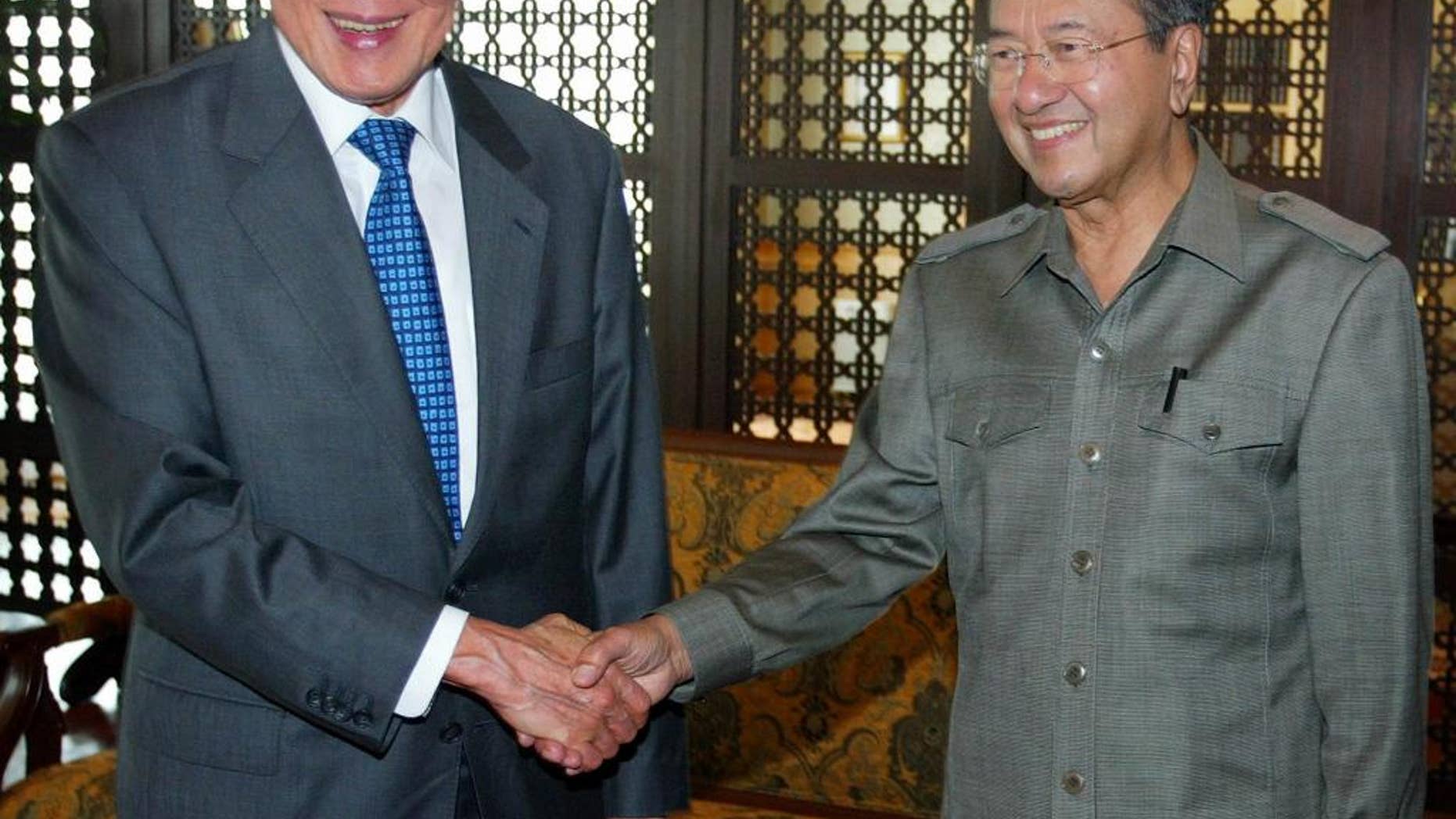FILE - In this April 27, 2005 file photo, Singapore Minister Mentor Lee Kuan Yew, left, and former Malaysian Prime Minister Mahathir Mohamad shake hands at the latter's office in Putrajaya, outside Kuala Lumpur. Two of Asia’s best-known strongmen, Singapore’s Lee Kuan Yew and Malaysia’s Mahathir Mohamad, had much in common - a streak of authoritarianism, little tolerance for dissent and vision that changed the face of their countries. But friends they were not, and the two rarely saw eye to eye. (AP Photo/Bazuki Muhammad, File)