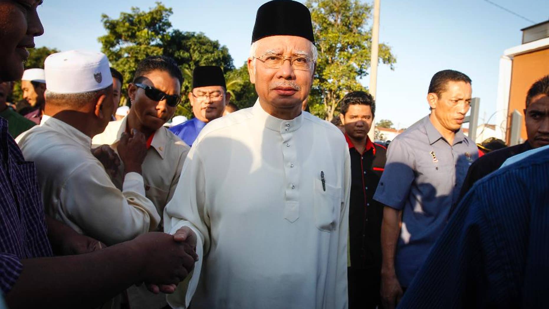 Malaysian Prime Minister Najib Razak arrives for a Ramadan breakfast at a mosque in Semenyih outside Kuala Lumpur, Malaysia on Sunday, July 5, 2015. Razak is facing the risk of criminal charges over allegations that hundreds of millions of dollars were funneled from an indebted state fund to his personal bank accounts, the first time a Malaysian leader has faced criminal allegations. (AP Photo/Joshua Paul)