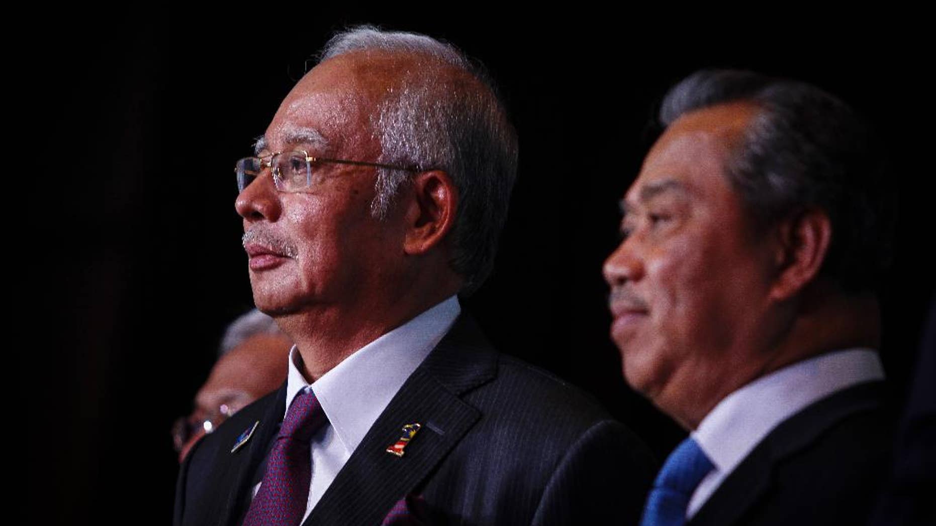In this April 7, 2015 photo, Malaysian Prime Minister Najib Razak, left, and Deputy Prime Minister Muhyiddin Yassin attends the launch of the Malaysian Education Blue Print at a hotel in Kuala Lumpur, Malaysia. In an interview Thursday April 9, 2015, Najib pledged there will be no cover-up in the investigation of a debt-laden state investment fund and reiterated he is not involved in the murder of a Mongolian woman nine years ago. (AP Photo/Joshua Paul)