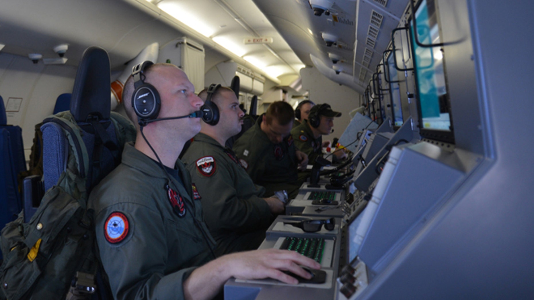 In this photo provided by the U.S. Navy, crew members on board an aircraft P-8A Poseidon assist in search and rescue operations for Malaysia Airlines flight MH370 in the Indian Ocean on Sunday, March 16, 2014. Malaysian authorities on Sunday examined a flight simulator that was confiscated from the home of one of the missing jetliner's pilots. The Boeing 777 went missing less than an hour into a March 8, flight from Kuala Lumpur to Beijing as it entered Vietnamese airspace. (AP Photo/U.S. Navy, Eric A. Pastor)