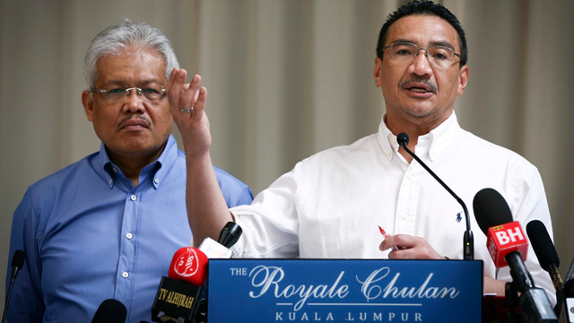 April 19, 2014: Malaysian Deputy Minister of Foreign Affairs Hamzah Zainudin, left, listens as Malaysia's acting Transport Minister Hishammuddin Hussein answers a question from a journalist during a press conference on the missing Malaysia Airlines Flight 370 at a hotel in Kuala Lumpur. (AP Photo/Vincent Thian)