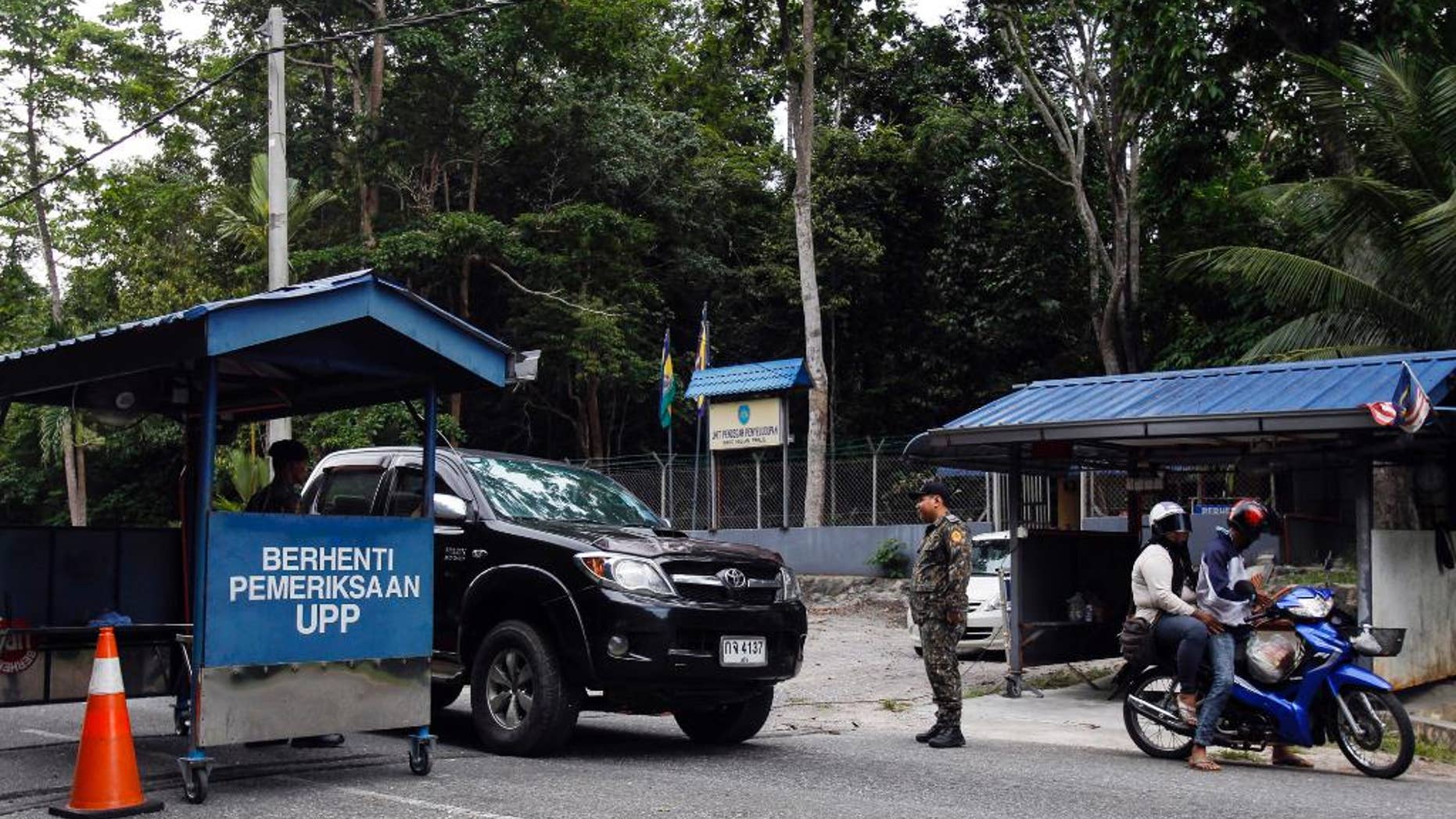 May 24, 2015: Malaysian Anti-Smuggling Unit officers check on vehicles at the entry point of Malaysia - Thailand border in Wang Kelian, Malaysia.
