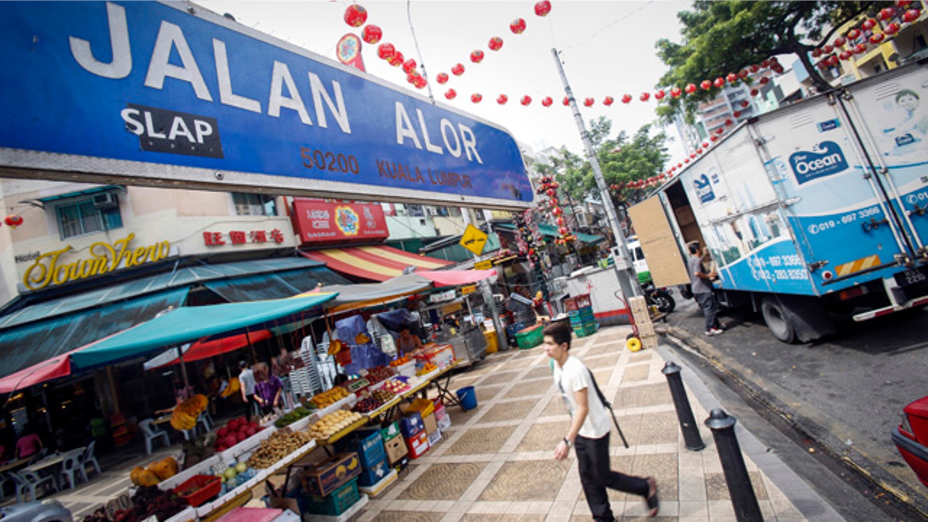 Sept. 25, 2015: A tourist walks past Malaysia's famous eatery street, Jalan Alor, a popular tourist spot in Kuala Lumpur. The U.S. Embassy issued an advisory Thursday saying it has credible threat information and urged its citizens to avoid Alor Street, located in a shopping belt in the city center, and its immediate surrounding areas. (AP Photo/Joshua Paul)