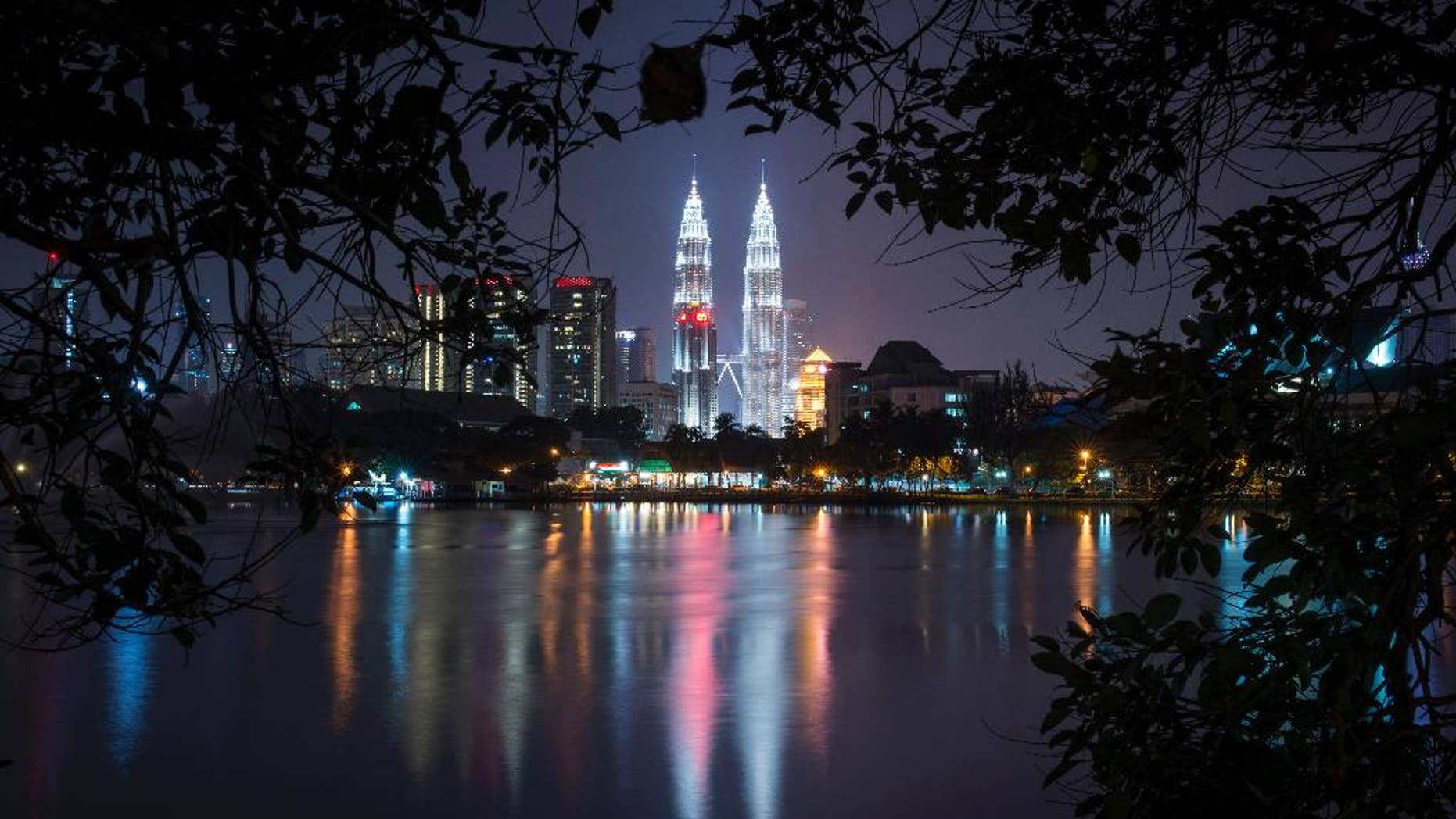 Malaysia's landmark Petronas Twin Towers illuminates the night skyline in Kuala Lumpur, Malaysia, Monday, April 6, 2015. Malaysia's police chief said Monday that 17 suspected militants were detained Sunday for allegedly plotting to carry out terrorist acts in the country's largest city. Inspector General of Police Khalid Abu Bakar tweeted that two of them had just returned from Syria. (AP Photo/Joshua Paul)