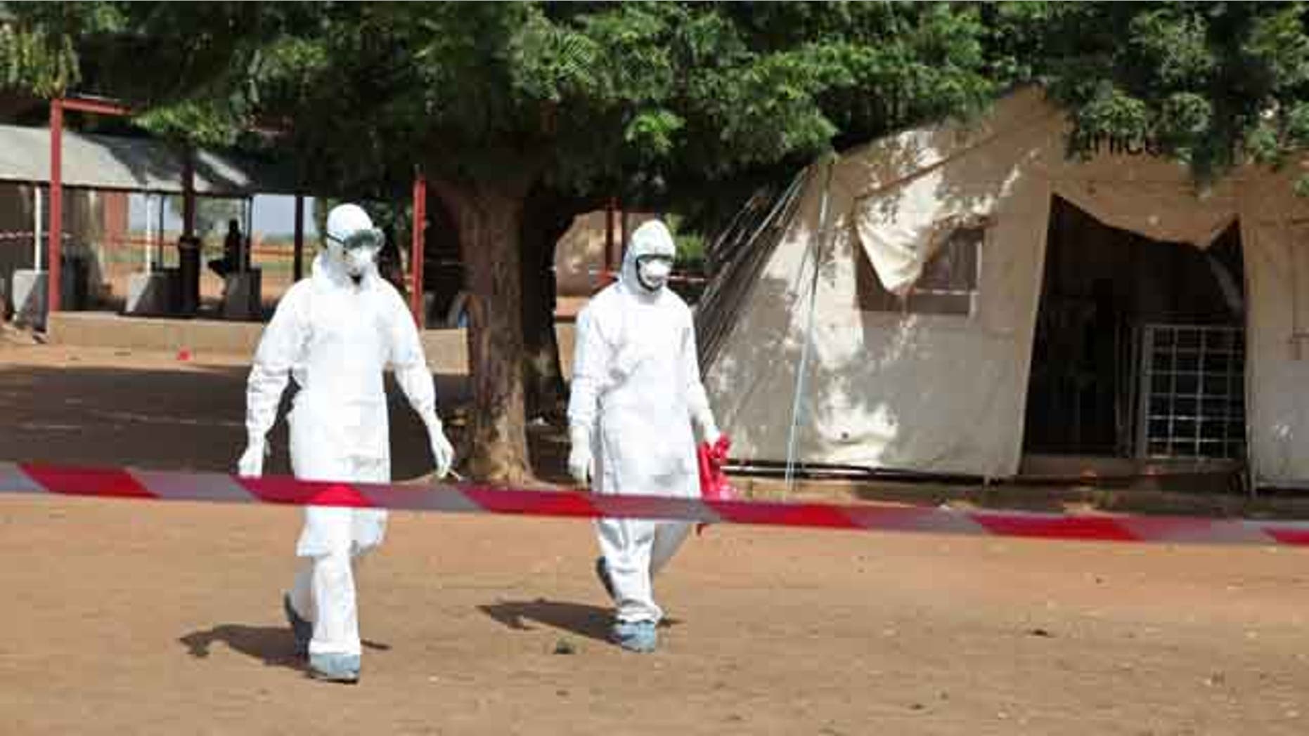 October 25, 2014: Health workers walk towards an area used for Ebola quarantine after they worked with diseased Fanta Kone at a Ebola virus center in Kayes, Mali. (AP Photo/Baba Ahmed)