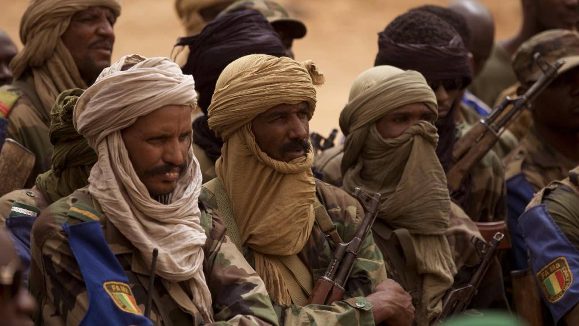 FILE - In this July 27, 2013 file photo, Malian Tuareg soldiers loyal to Col. Major El-Hadj Gamou listen during a visit by Mali's army chief of staff in Kidal, Mali. Tuareg separatist rebels agreed to sign a peace deal with the government in just over a week’s time but that hasn’t stopped them from attacking towns and encroaching further south toward Mali’s capital. The toll has risen to 30 dead in recent days. (AP Photo/Rebecca Blackwell, File)