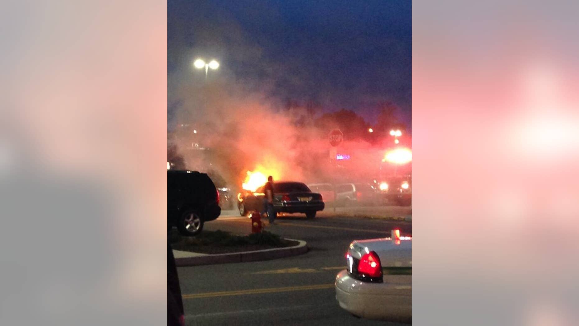 This photo provided by Brittany Berdy shows a car fire that authorities believe may have led to reports of gunshots that forced them to evacuate the Garden State Plaza mall in Paramus, N.J., Saturday, May 10, 2014. New Jersey State Police Capt. Stephen Jones said that police have found no evidence that any shots were fired at the mall Saturday night. (AP Photo/Brittany Berdy)