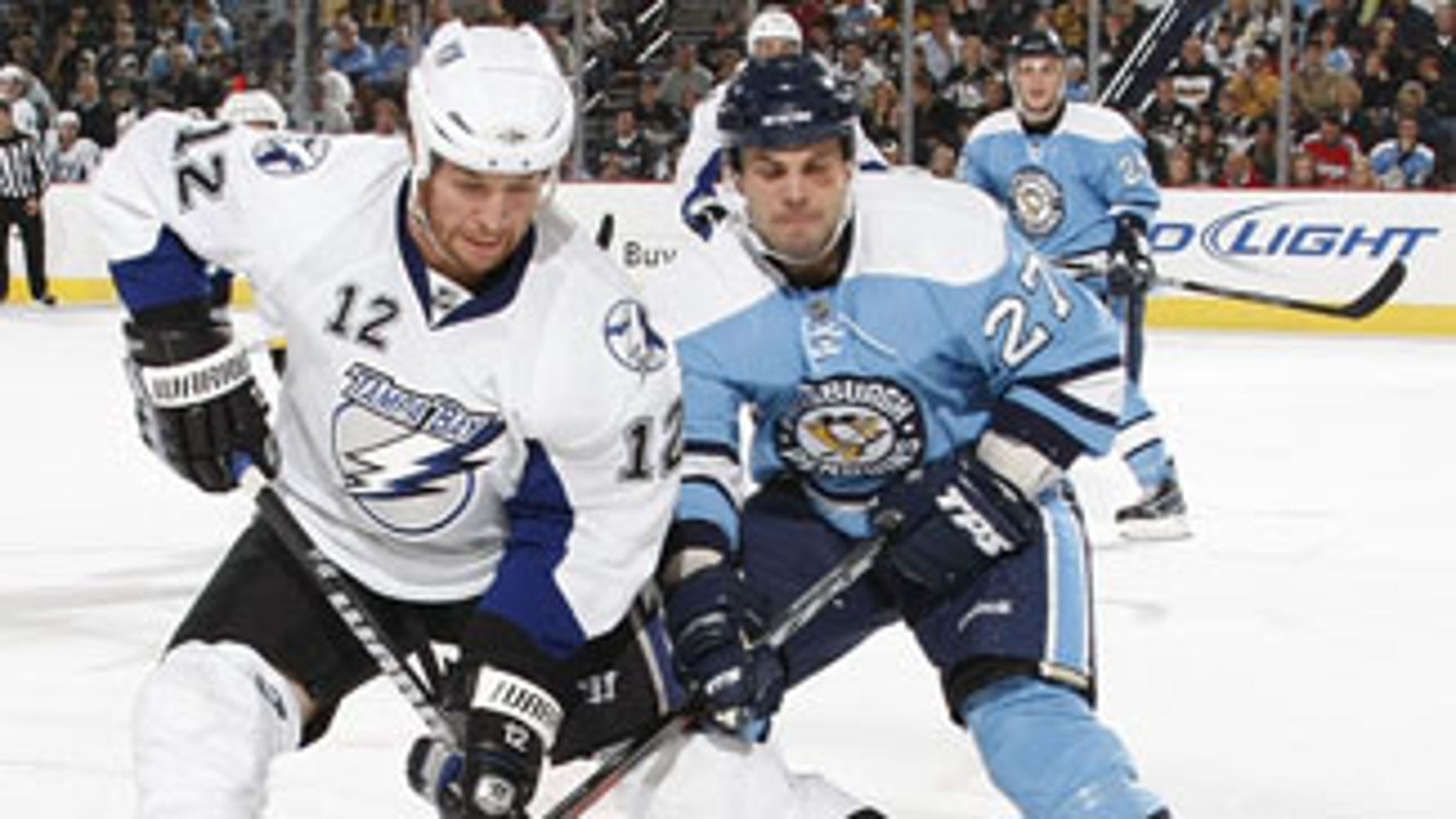 PITTSBURGH - OCTOBER 17: Ryan Malone #12 of the Tampa Bay Lightning controls the puck in front of the defense of Craig Adams #27 of the Pittsburgh Penguins on October 17, 2009 at Mellon Arena in Pittsburgh, Pennsylvania. (Photo by Gregory Shamus/NHLI via Getty Images) *** Local Caption *** Ryan Malone;Craig Adams