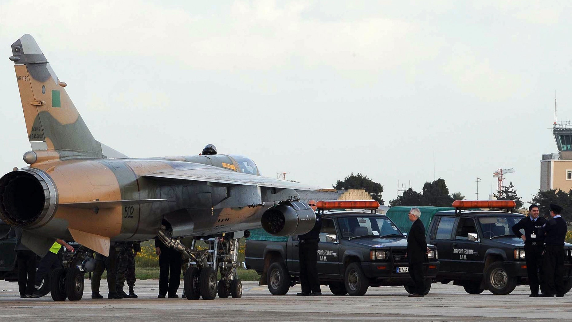 One of two Libyan Air Force Mirage jet fighters to land in Malta, is surrounded by Maltese police after it landed in Malta's International airport, Monday, Feb. 21, 2011.