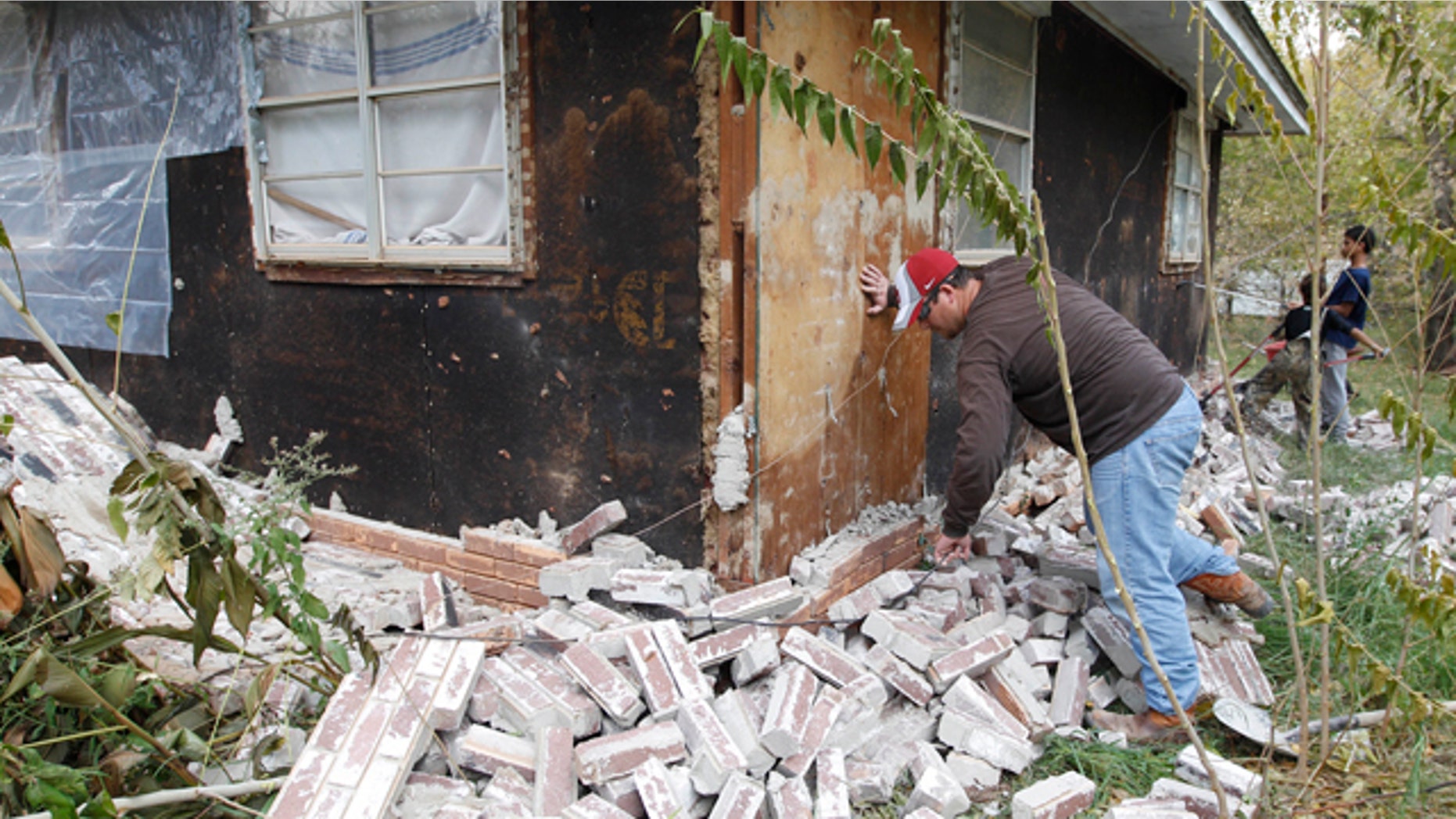 Nov. 6, 2011: Chad Devereaux examines bricks that fell from three sides of his in-laws home from an earthquake in Sparks, Okla.
