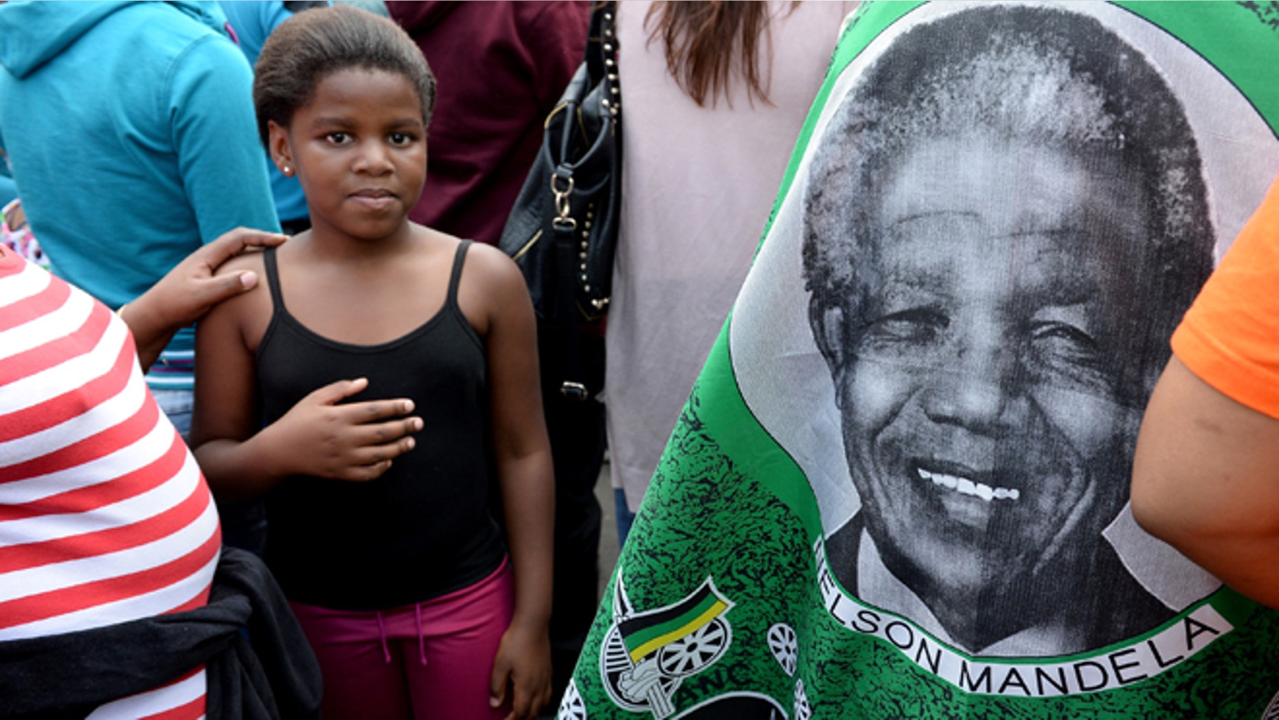 JOHANNESBURG, SOUTH AFRICA - DECEMBER 07: South Africans gather to pay respect and tribute to former President Nelson Mandela outside his Houghton home on December 7, 2013 in Johannesburg, South Africa. Crowds gather at his home as vigils continue across South Africa as thousands mourn the death of former leader Nelson Mandela. Mr Mandela, died on Thursday aged 95, spent 27 years in jail before becoming South Africa's first black president in 1994.. (Photo by Jeff J Mitchell/Getty Images)