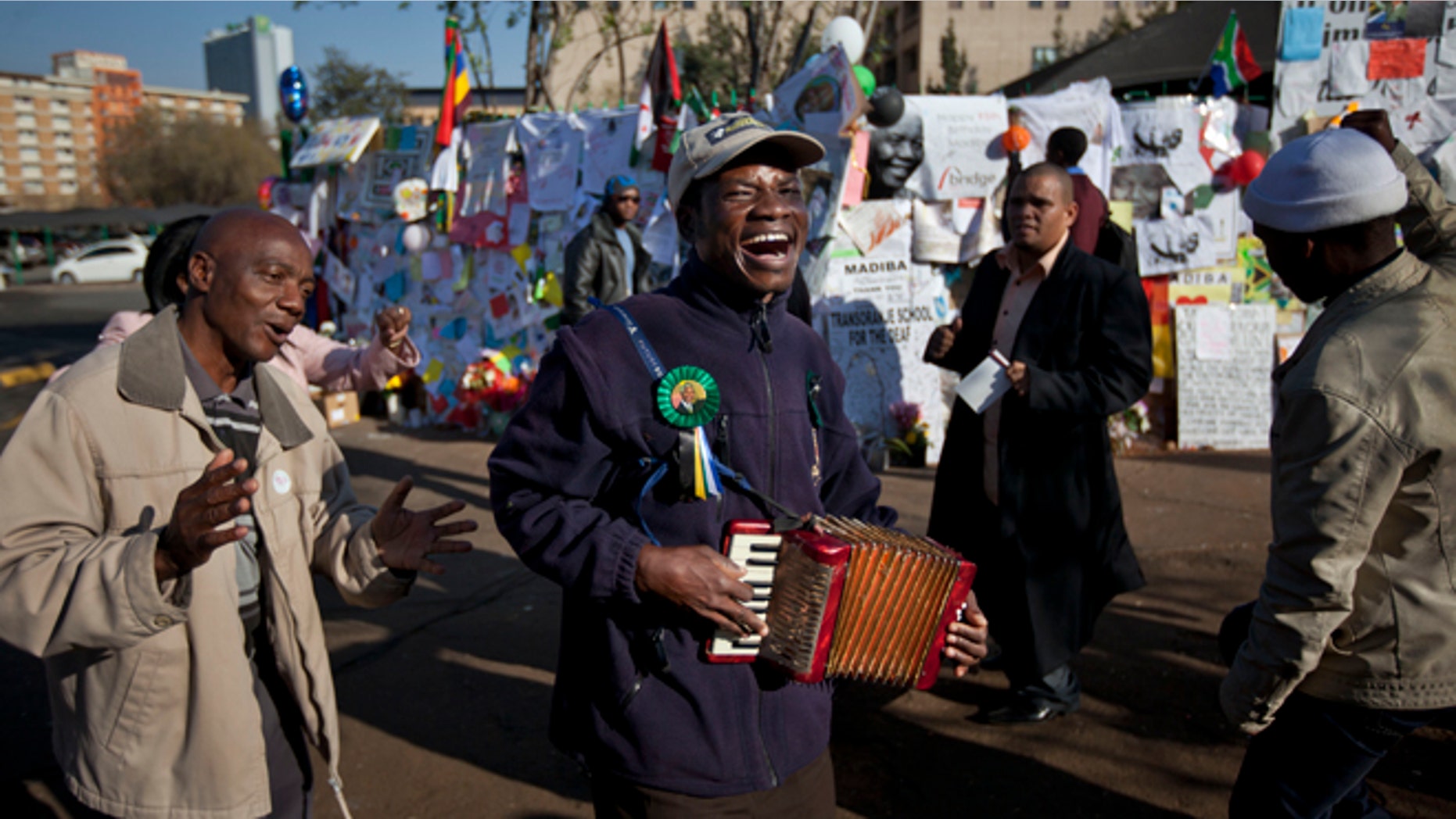 July 19, 2013: Well-wishers sing and dance to the sound of an accordion outside the Mediclinic Heart Hospital where former South African President Nelson Mandela is being treated in Pretoria, South Africa.