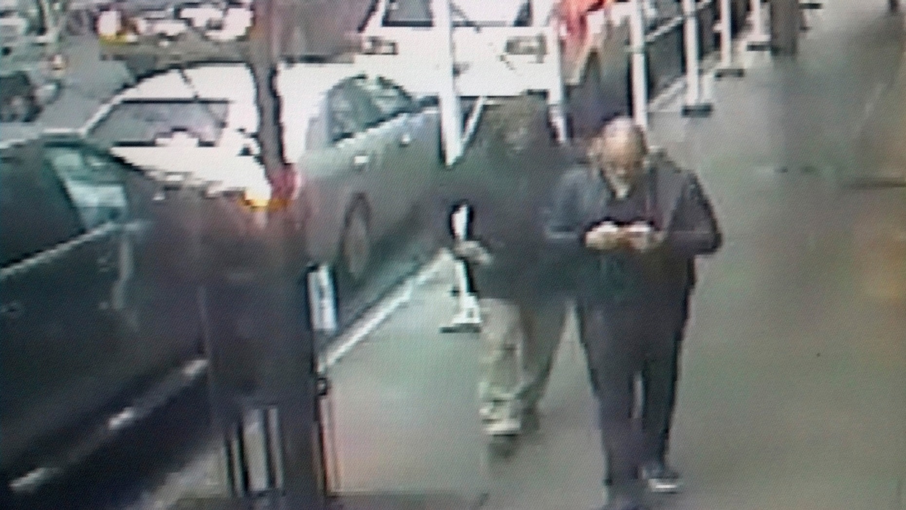 This still image made from a video provided by the New York City Police Department shows the gunman, left, behind Brandon Lincoln Woodard pulling the weapon from his jacket pocket a moment before the shooting.