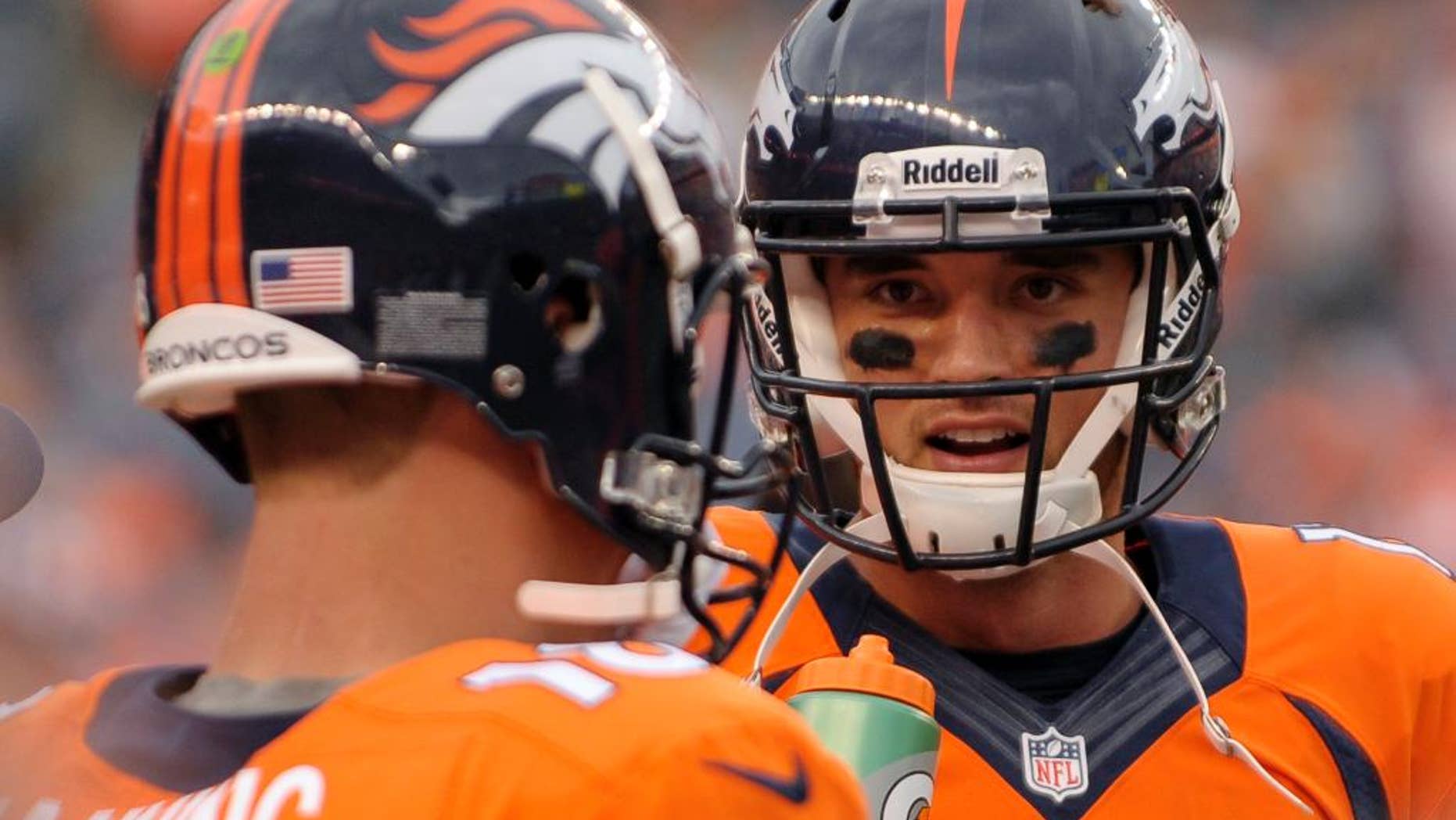 FILE - In this Sept. 29, 2013, file photo, Denver Broncos quarterback Brock Osweiler (17) talks with Peyton Manning (18) during an NFL football game against the Philadelphia Eagles in Denver. There was a time when Brock Osweiler, who's entering his third year of an extended apprenticeship under Peyton Manning, wanted to seek out Aaron Rodgers to pick his brain about how he learned under Brett Favre. Instead, he decided to figure it out for himself. (AP Photo/Jack Dempsey, File)