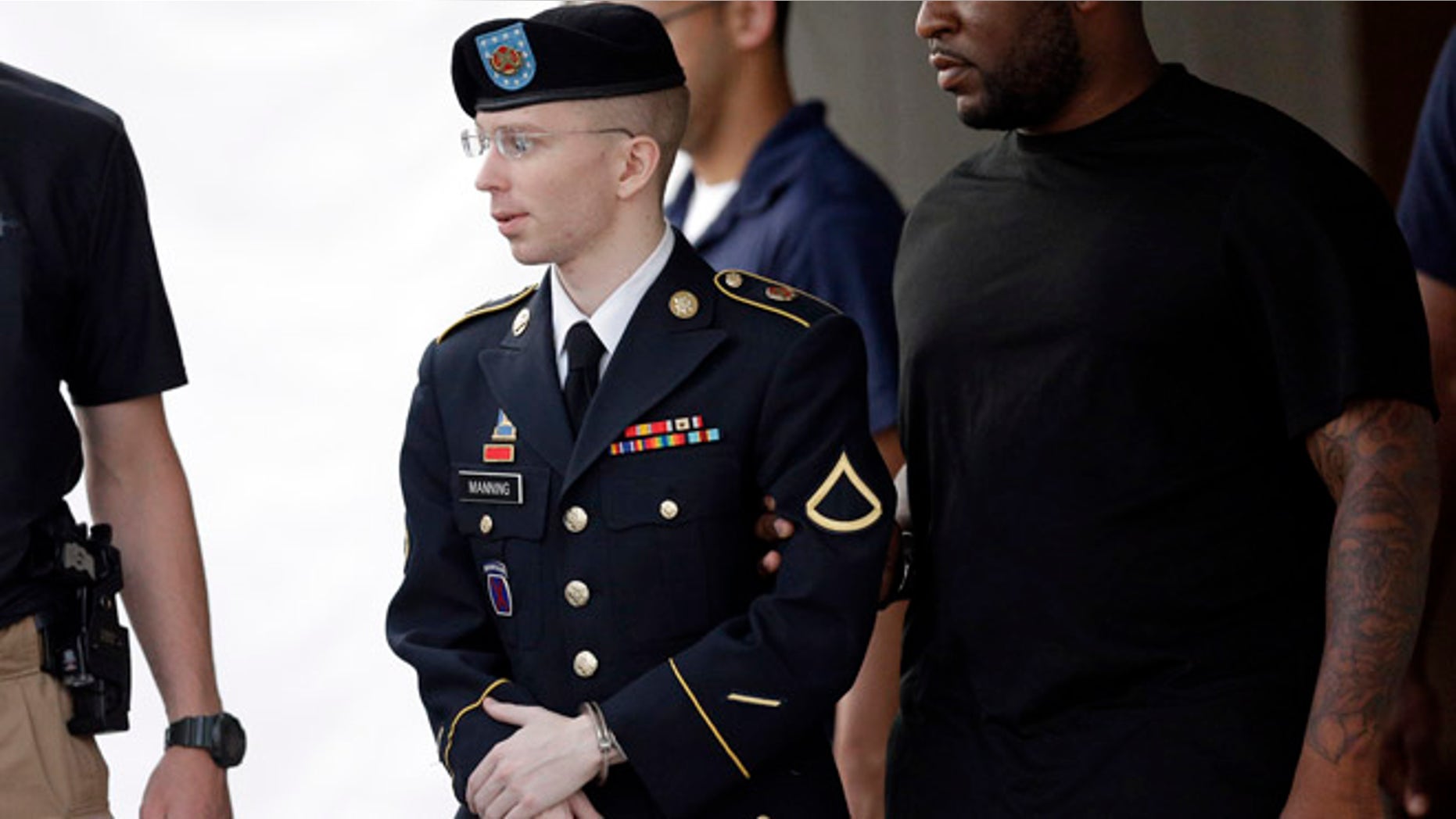 July 15, 2013: Army Pfc. Bradley Manning, center, is escorted to a waiting security vehicle outside of a courthouse in Fort Meade, Md., after appearing for a hearing at his court martial.