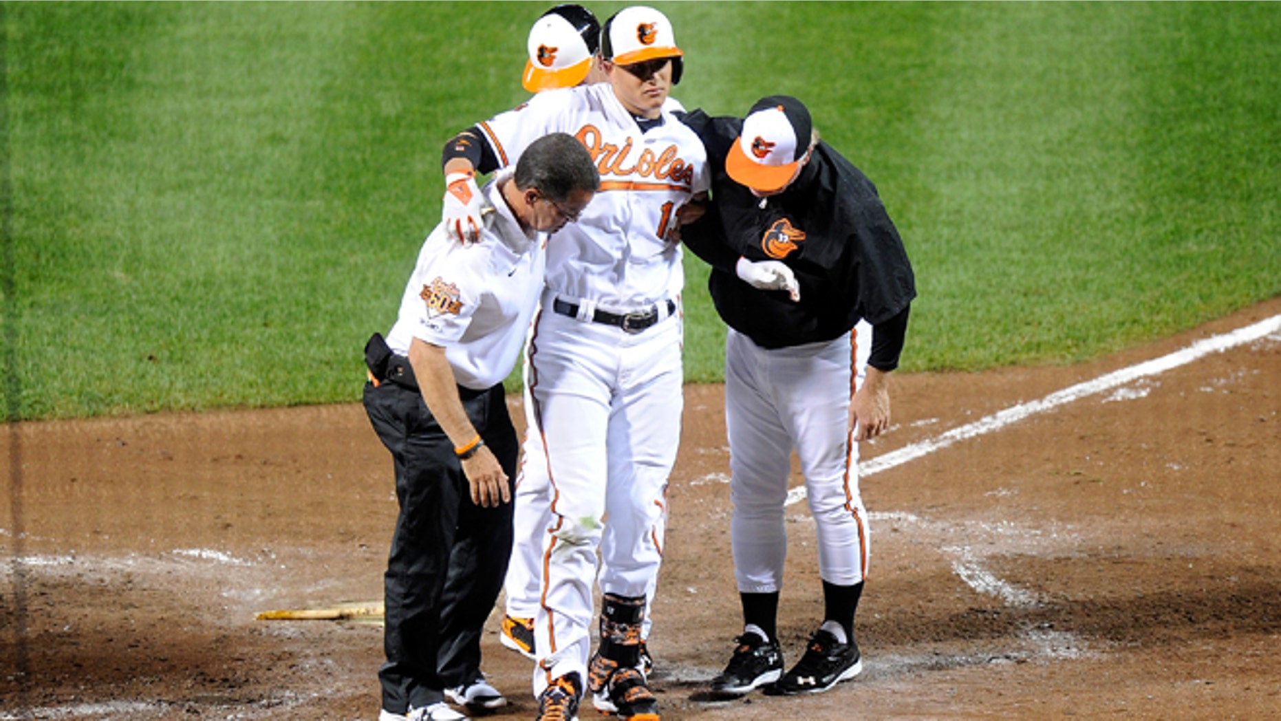 BALTIMORE, MD - AUGUST 11: Manny Machado #13 of the Baltimore Orioles is helped off the field after injuring his leg in the third inning against the New York Yankees at Oriole Park at Camden Yards on August 11, 2014 in Baltimore, Maryland. (Photo by Greg Fiume/Getty Images)