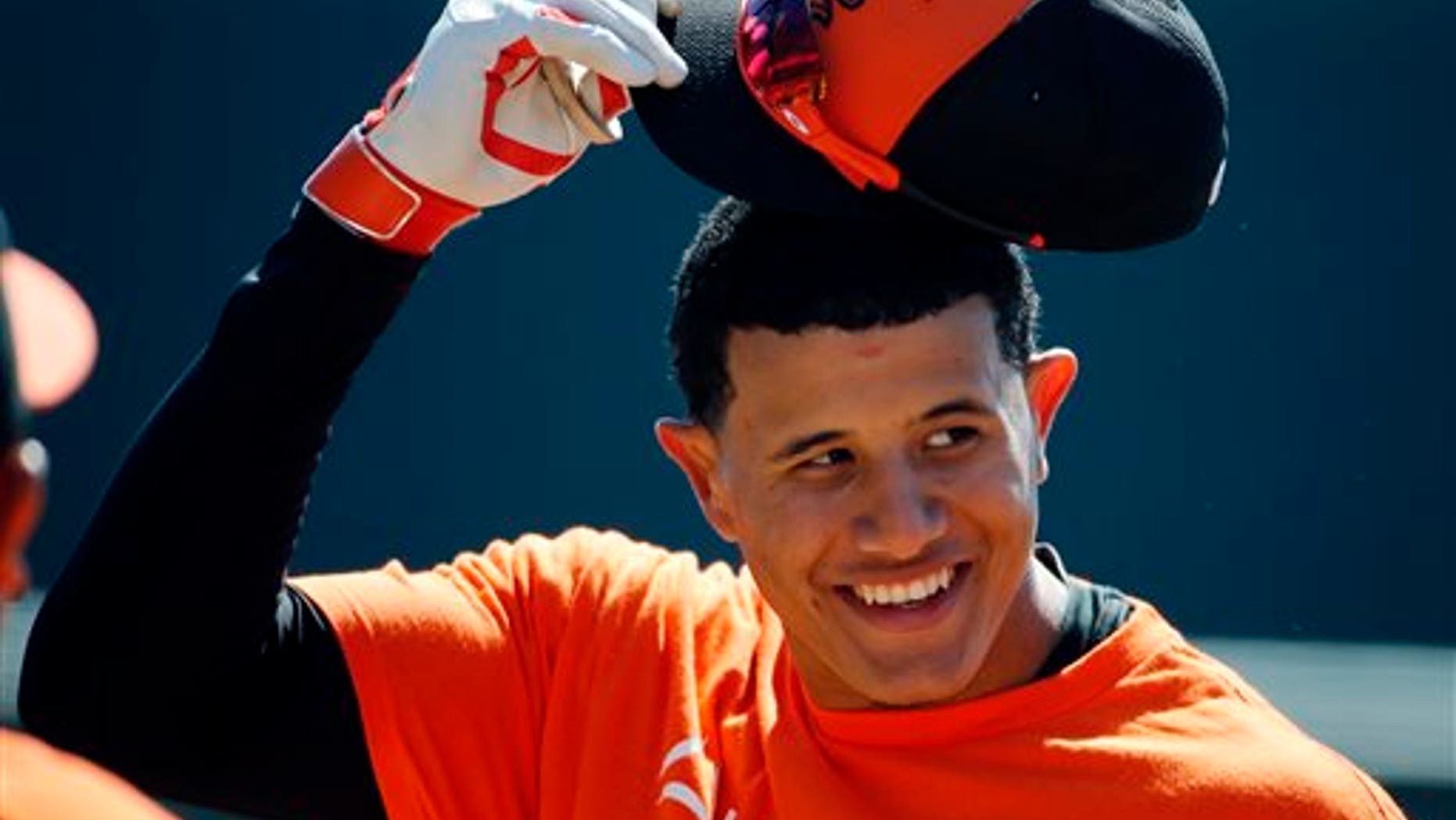 Baltimore Orioles' Manny Machado takes off his hat before going into the batting cage to hit before an exhibition spring training baseball game against the Boston Red Sox in Sarasota, Fla., Saturday, March 8, 2014. (AP Photo/Gene J. Puskar)