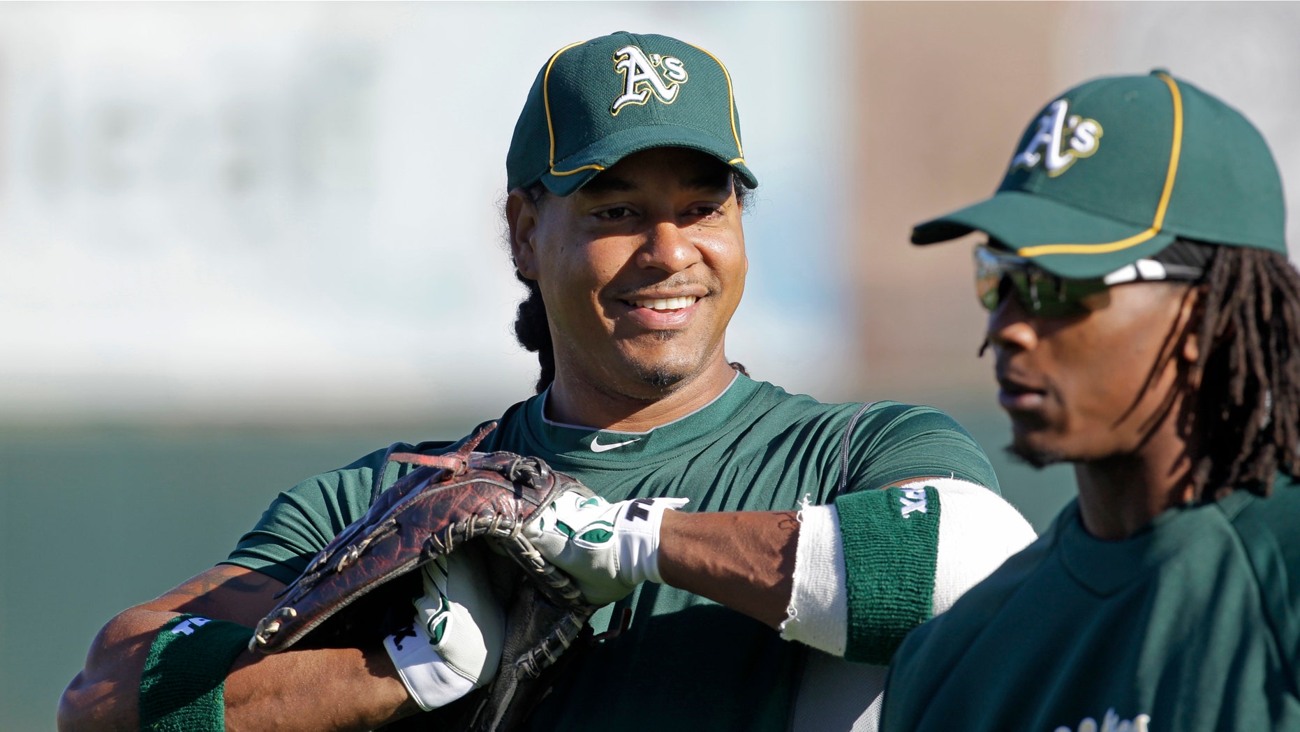 Oakland Athletics' Manny Ramirez, left, talks with Jemile Weeks during a spring training baseball workout Friday, Feb. 24, 2012, in Phoenix. (AP Photo/Darron Cummings)