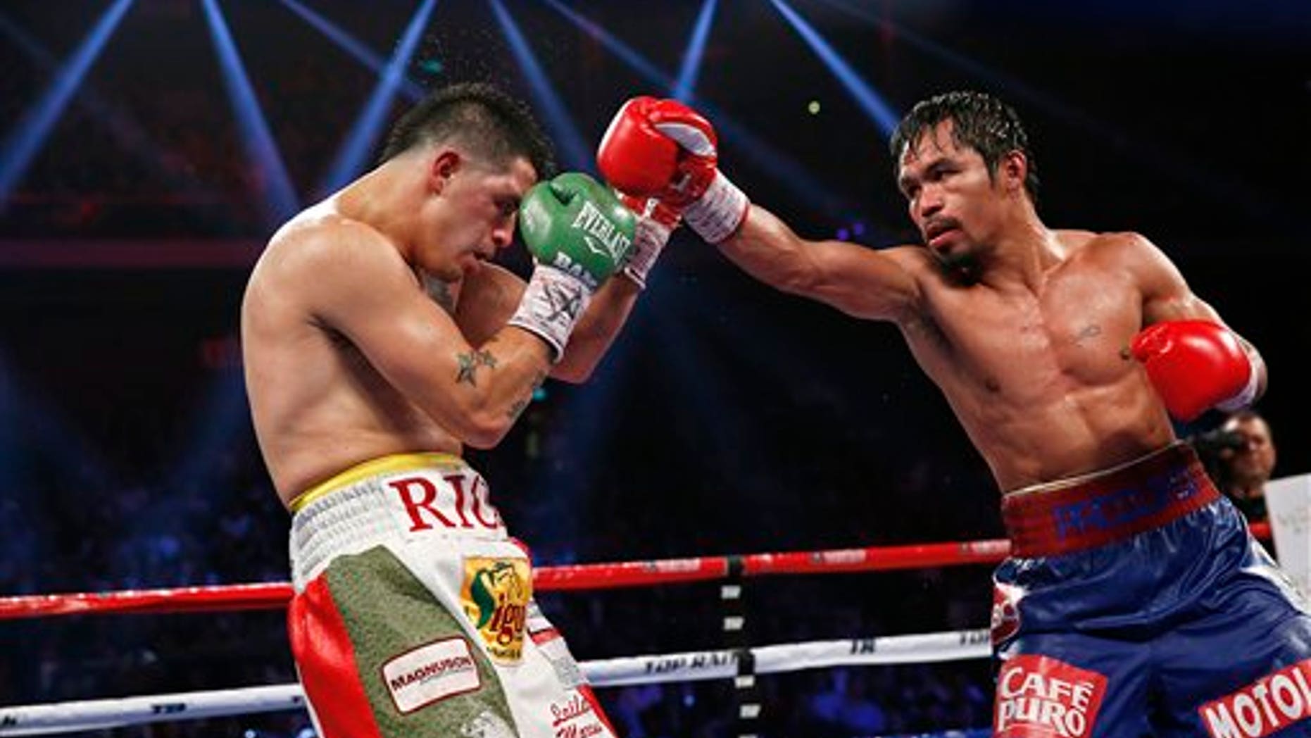 Manny Pacquiao, from the Philippines, right, punches Brandon Rios of the United States during their WBO international welterweight title fight Sunday, Nov. 24, 2013, in Macau. Pacquiao defeated Rios by unanimous decision on Sunday to take the WBO international welterweight title and return to his accustomed winning ways after successive defeats. (AP Photo/ Vincent Yu)