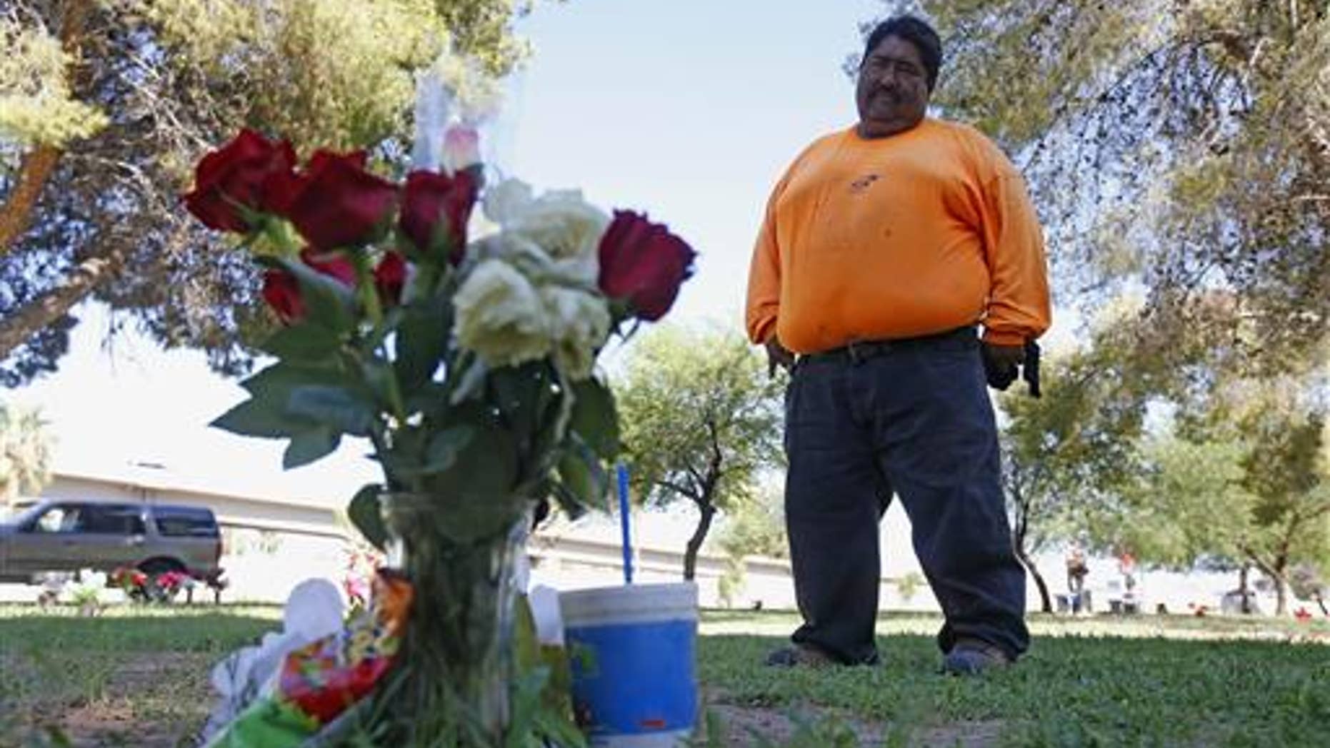 Margarito Castro, father of late "Manny," visits his son's grave at a cemetery Thursday, July 14, 2016, in Phoenix.