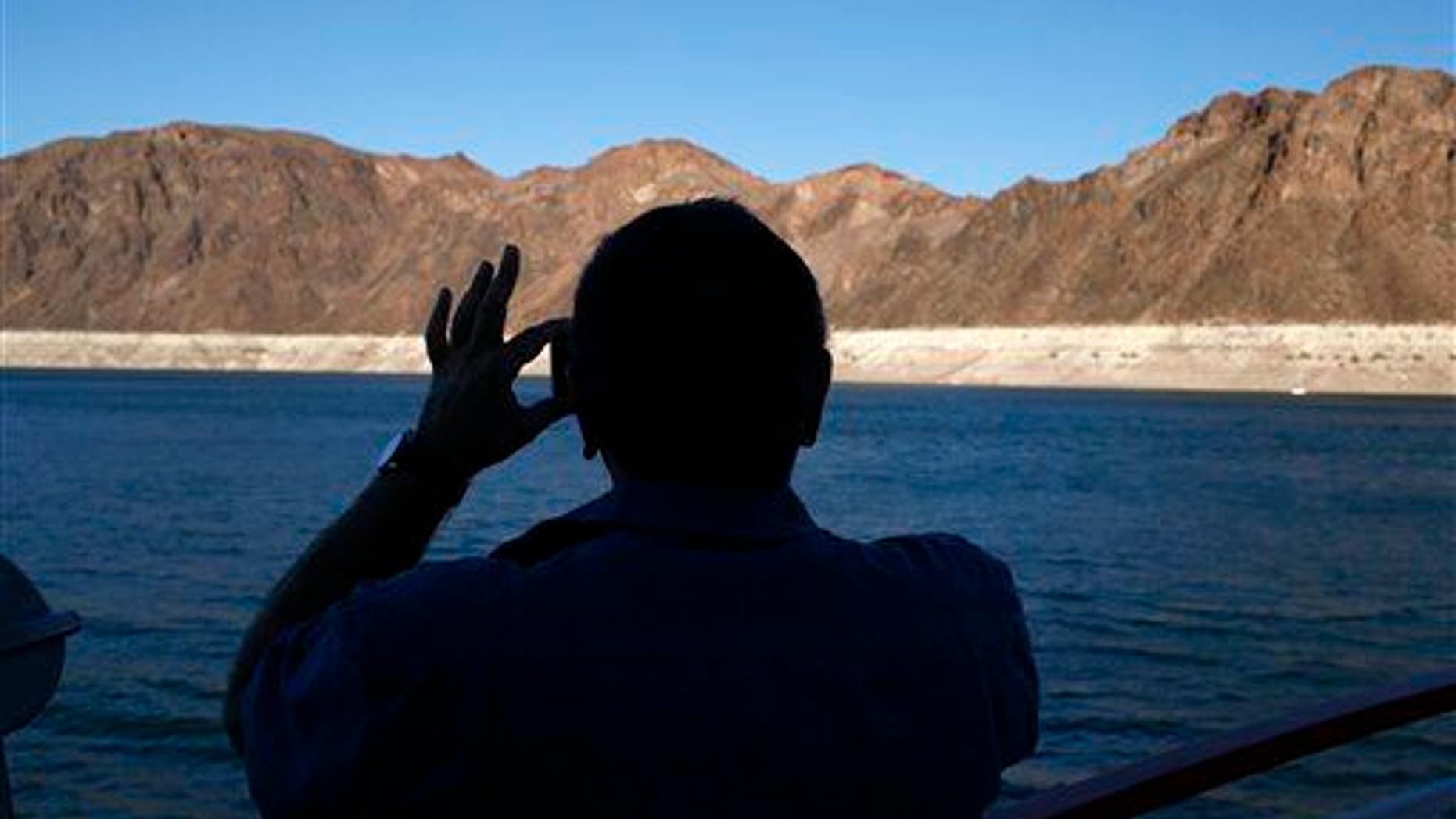 In this July 20, 2014 photo, a man takes a picture while taking a cruise at the Lake Mead National Recreation Area in Nevada.