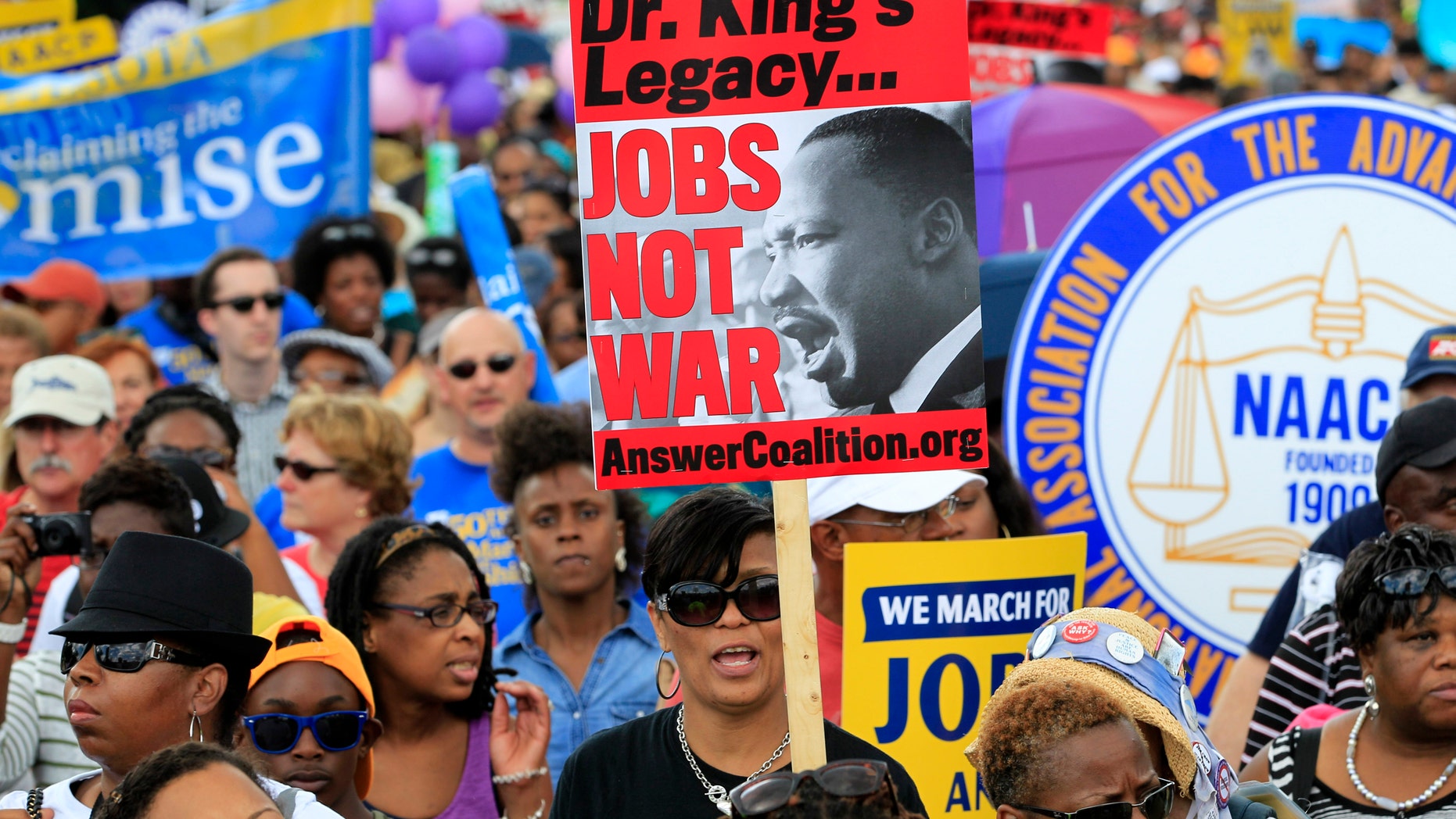 Demonstrators march towards the Martin Luther King Junior Memorial during the rally to commemorate the 50th anniversary of the 1963 March on Washington Saturday, Aug. 24, 2013, in Washington.