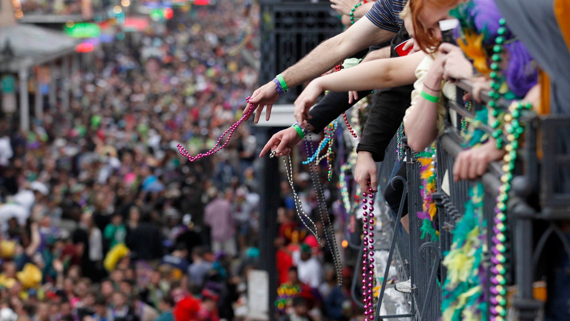 In this March 8, 2011 file photo, revelers throw beads from the balcony of the Royal Sonesta Hotel onto crowds on Bourbon Street during Mardi Gras Day festivities in the French Quarter in New Orleans. Mardi Gras this year is on Tuesday, Feb. 12, 2013, but more than a dozen parades roll in the days leading up to Fat Tuesday.
