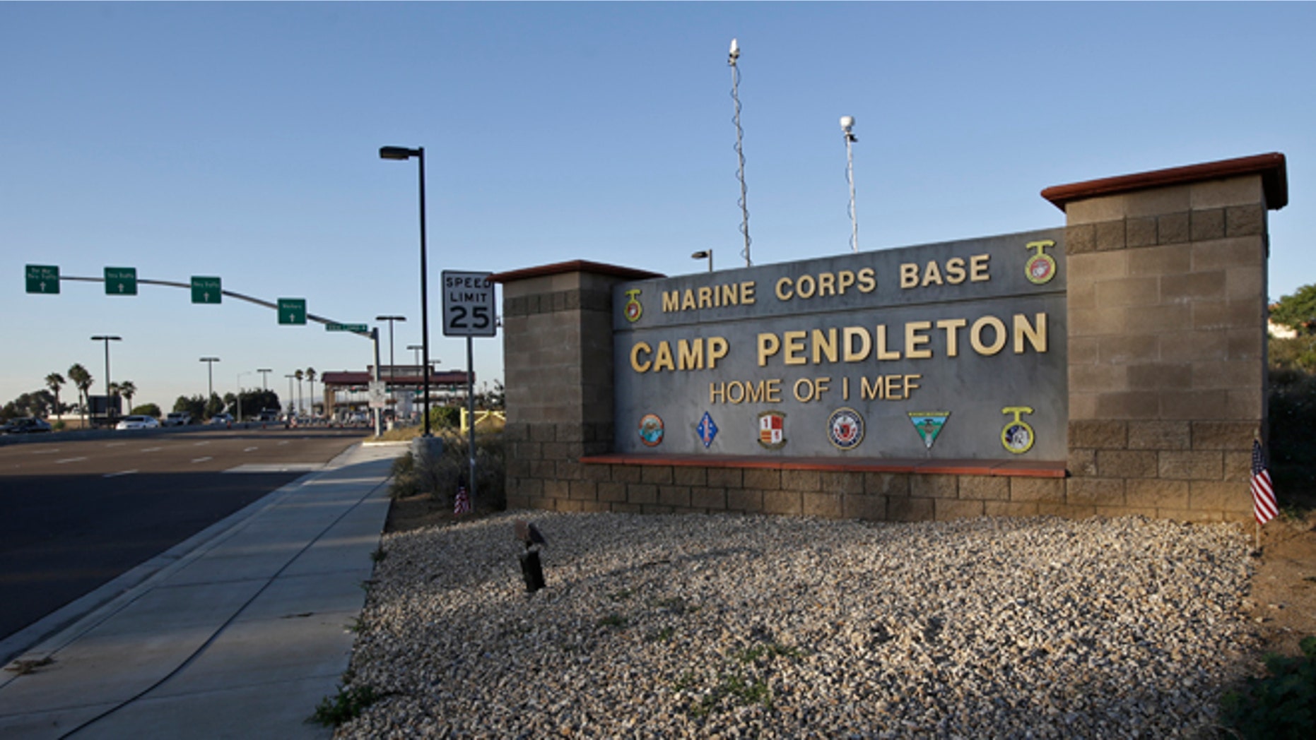 Vehicles file through the main gate of Camp Pendleton Marine Base on Wednesday, Nov. 13, 2013, at Camp Pendleton, Calif. Four Marines were reported killed today in an accident while clearing an unexploded ordnance. (AP Photo/Lenny Ignelzi)