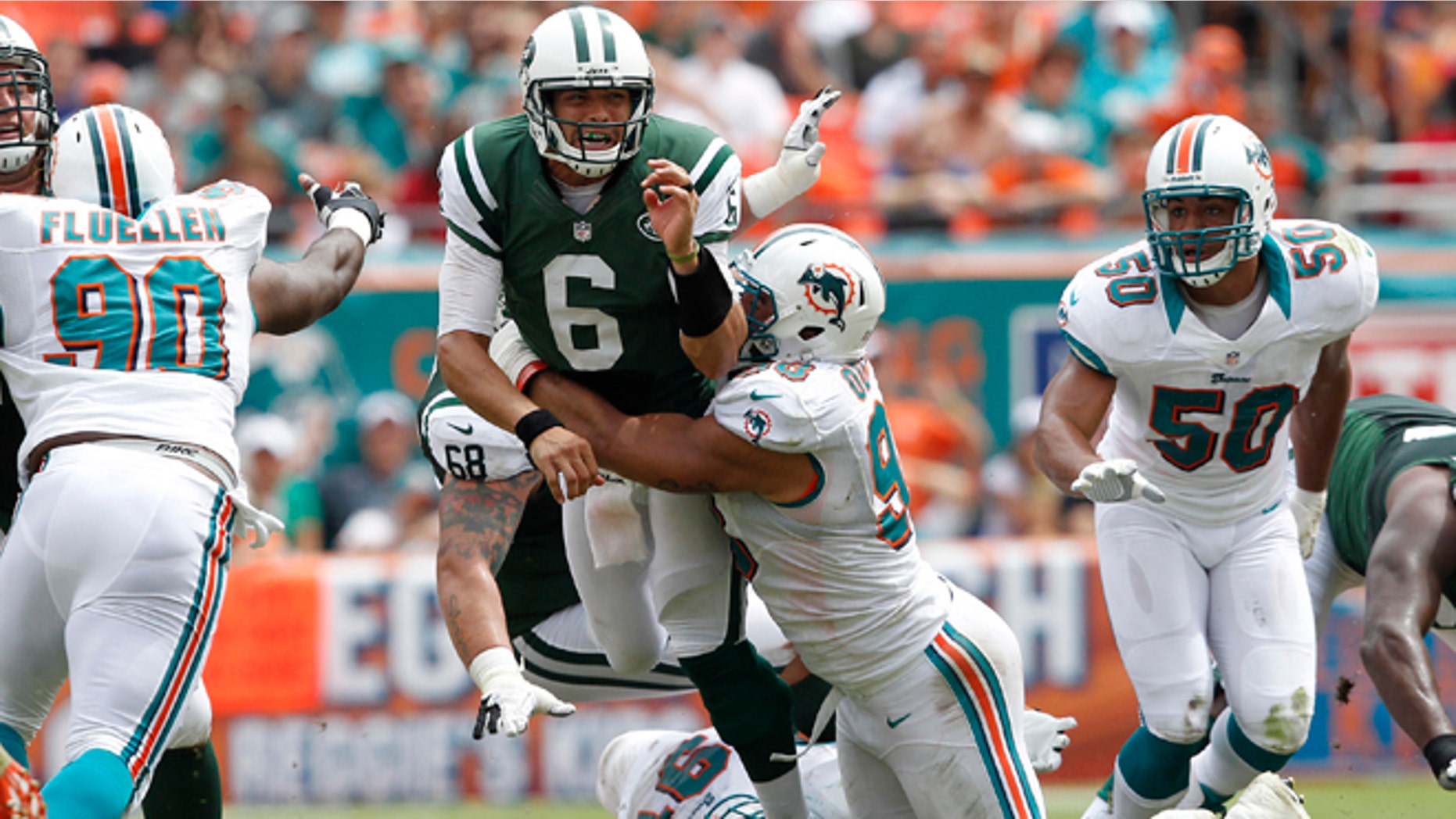 MIAMI GARDENS, FL - SEPTEMBER 23: Jared Odrick #98 of the Miami Dolphins hits Mark Sanchez #6 of the New York Jets as he gets the ball away on September 23, 2012 at Sun Life Stadium in Miami Gardens, Florida. (Photo by Joel Auerbach/Getty Images)