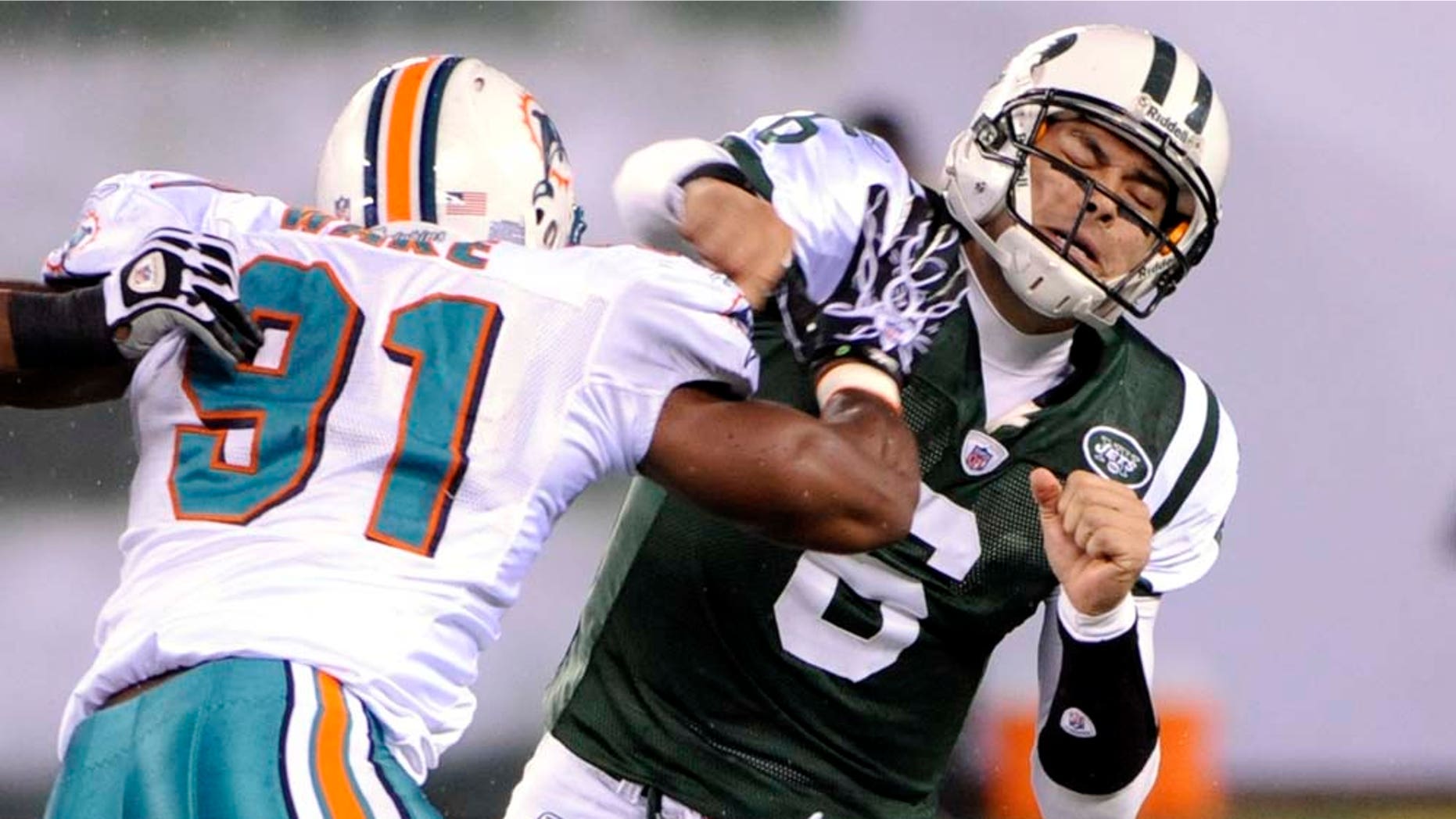 New York Jets quarterback Mark Sanchez (6) fumbles the ball as he is hit by Miami Dolphins linebacker Cameron Wake (91) during the second quarter of an NFL football game between the Miami Dolphins and the New York Jets at New Meadowlands Stadium Sunday, Dec. 12, 2010, in East Rutherford, N.J. The Jets recovered the fumble. (AP Photo/Bill Kostroun)