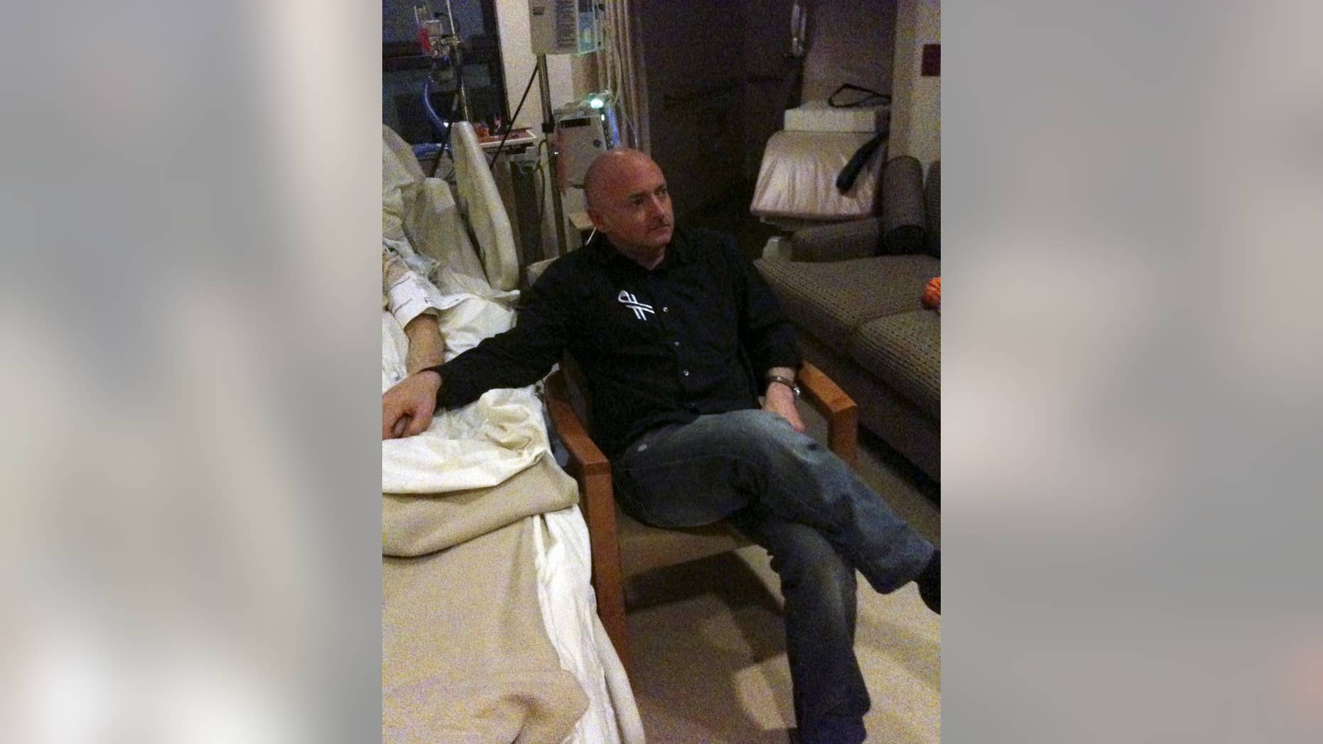 This photo provided by the office of U.S. Rep. Gabrielle Giffords shows Mark Kelly watching the State of the Union address with Giffords in her hospital room in Houston, Tuesday, Jan. 25, 2011. (AP Photo/Office of U.S. Rep. Gabrielle Giffords)