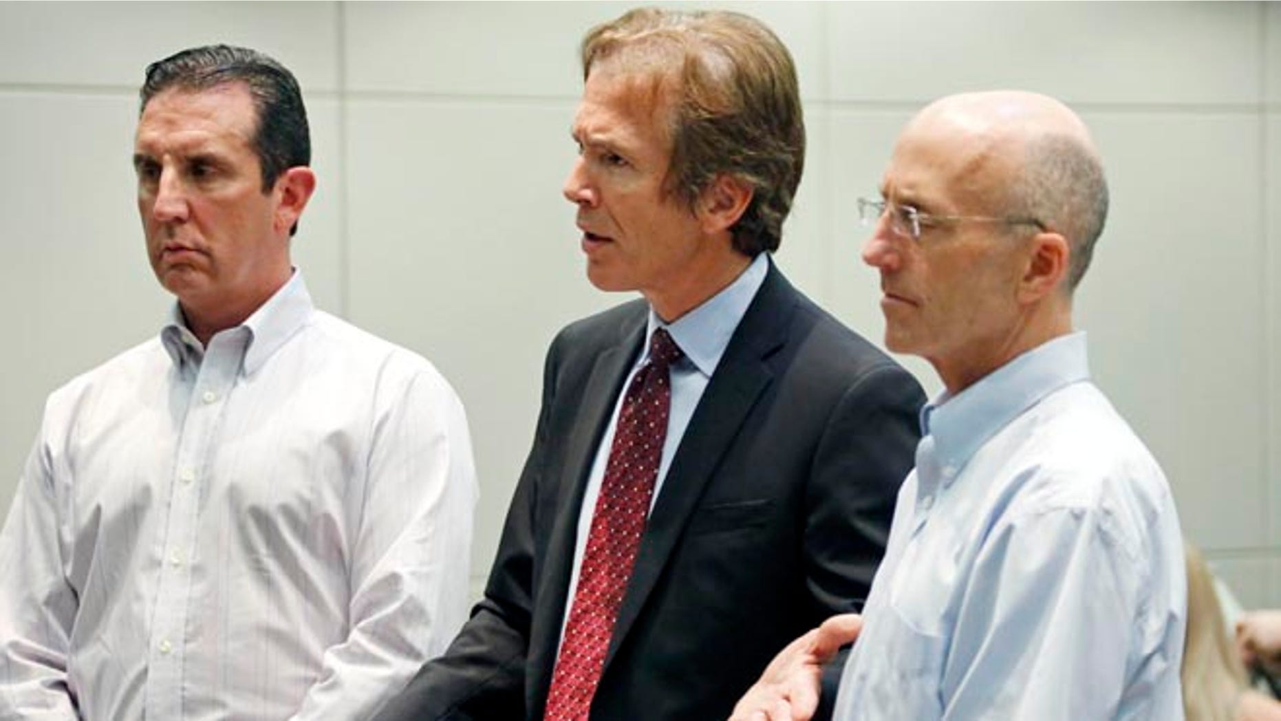 In this May 22, 2014 photograph, Mark Mayfield, right, a member of the board of the Central Mississippi Tea Party, and attorney John Reeves, left, listen as Mayfield's attorney Merrida Coxwell, center, responds to questions from city Judge Dale Danks in Madison, Miss., city court, during an initial court appearance.