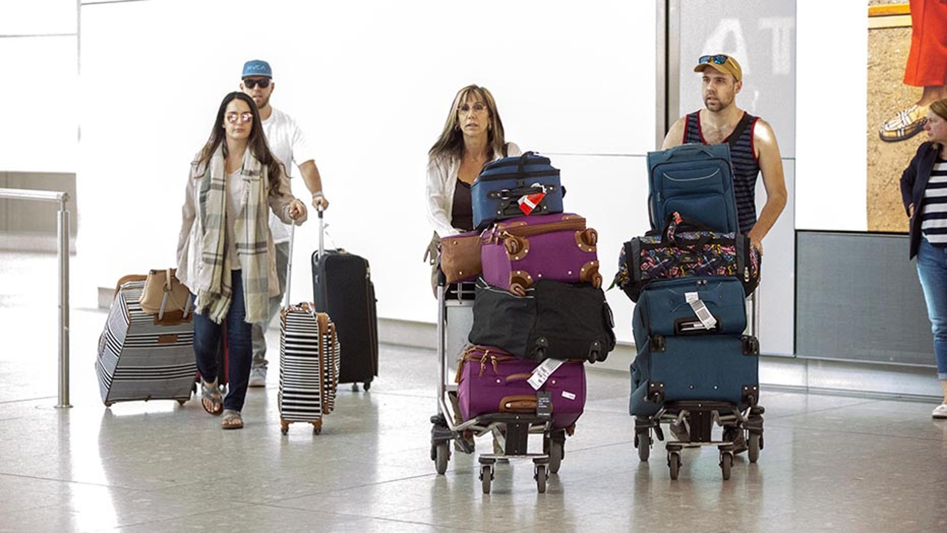 Meghan Markle's nephews Tyler and Thomas Dooley along with their mother Tracy Dooley Markle are pictured as they arrive at London Heathrow airport, despite not being invited to the wedding. The family is in the UK to be special correspondents on 'Great Morning Britain' for Meghan and Prince Harry's wedding this Saturday.