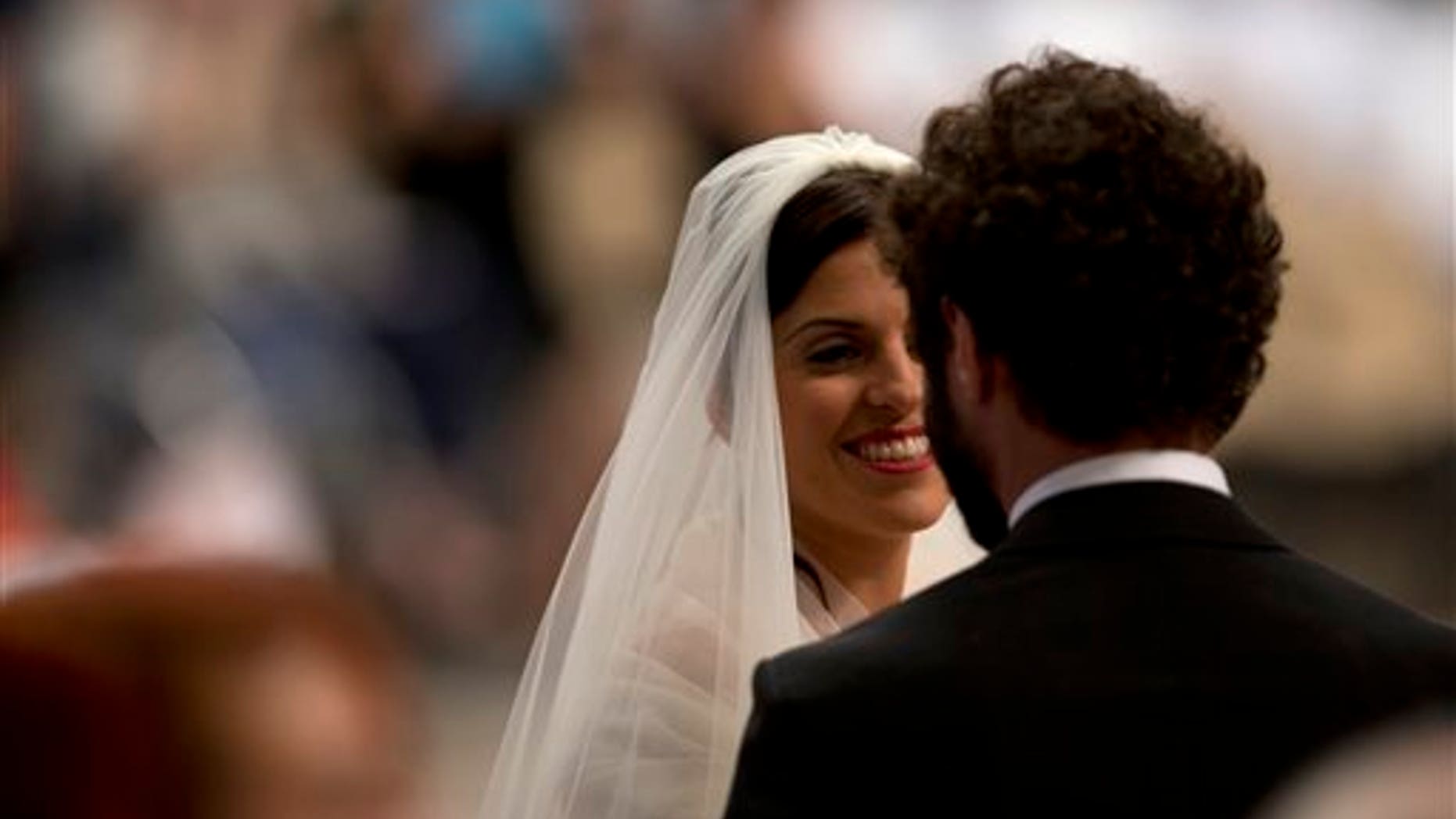 Alessandra Pucci smiles to Francesco Allotta after being married by Pope Francis, during a wedding ceremony in St. Peter's Basilica at the Vatican, Sunday, Sept. 14, 2014. Pope Francis married 20 couples Sunday, including some who already live together and those with children, technically a sin in the eyes of the church. (AP Photo/Alessandra Tarantino)