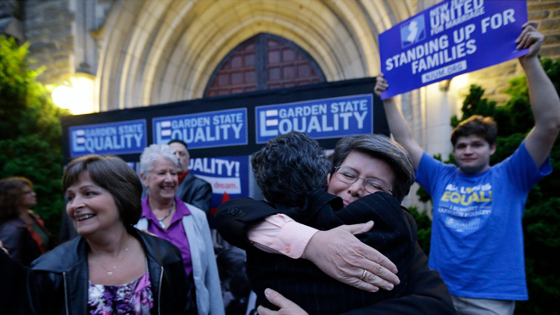 Sept. 27, 2013: Cindy Meneghin, second from right, hugs her attorney Hayley Gorenberg during a rally at Garden State Equality in Montclair, N.J., hours after a Superior Court Judge ruled that New Jersey is unconstitutionally denying federal benefits to gay couples and must allow them to marry. )