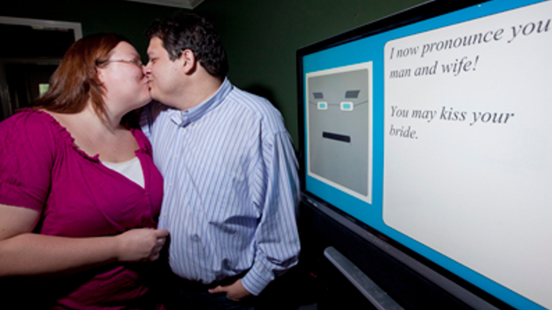 July 28, 2011: Miguel Hanson, right, kisses his fiancee Diana Wesley by the computer, in Humble, Texas. The couple couldn't get a friend to serve as the minister at their wedding, so they decided to create their own.