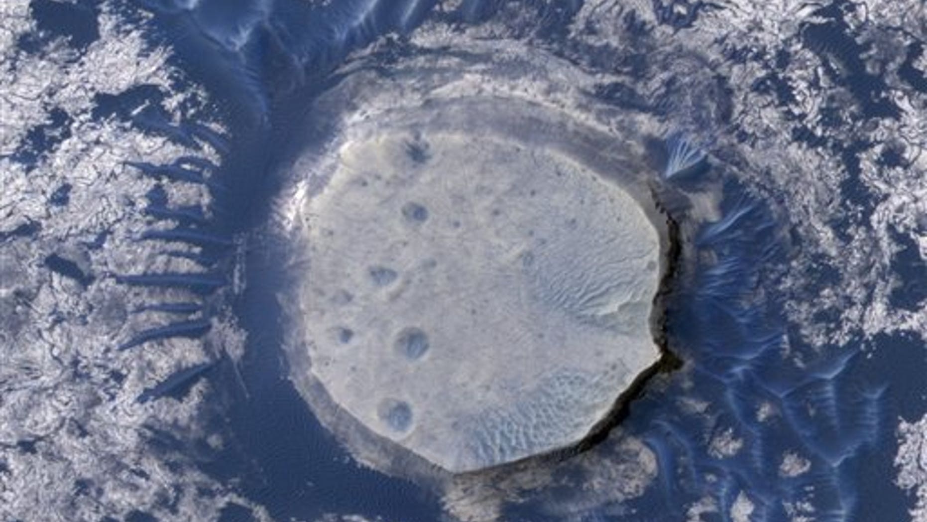 An inverted crater in the Arabia Terra region of Mars is among the images taken by NASA's Mars Reconnaissance Orbiter in early 2010. Scientists are impressed with the flood of data beamed back by the craft; the space agency said the Orbiter has sent back 100 terabits of data: equal to about 3 million MP3s.